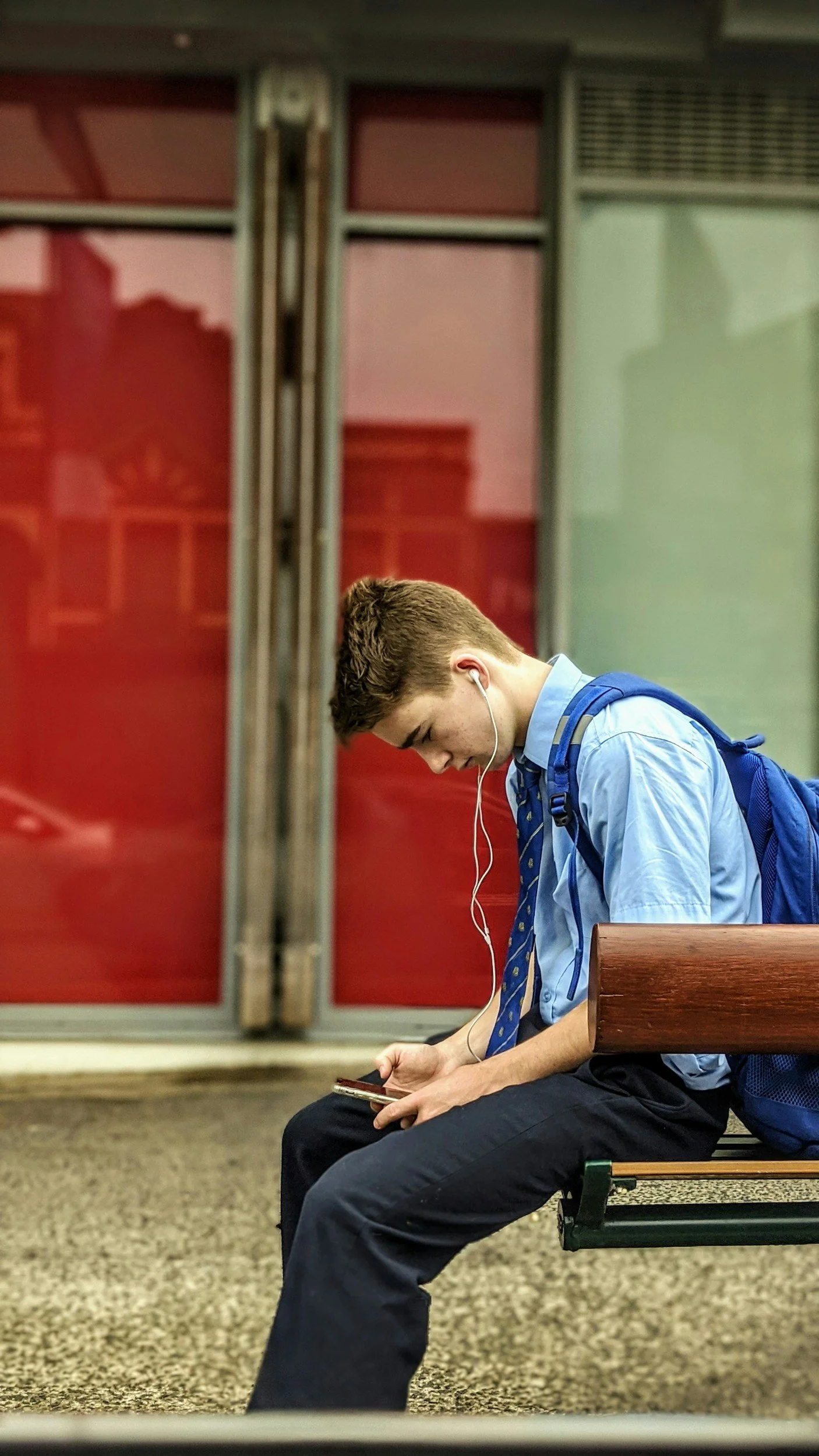 an autistic teen sitting outside of school, overwhelmed.