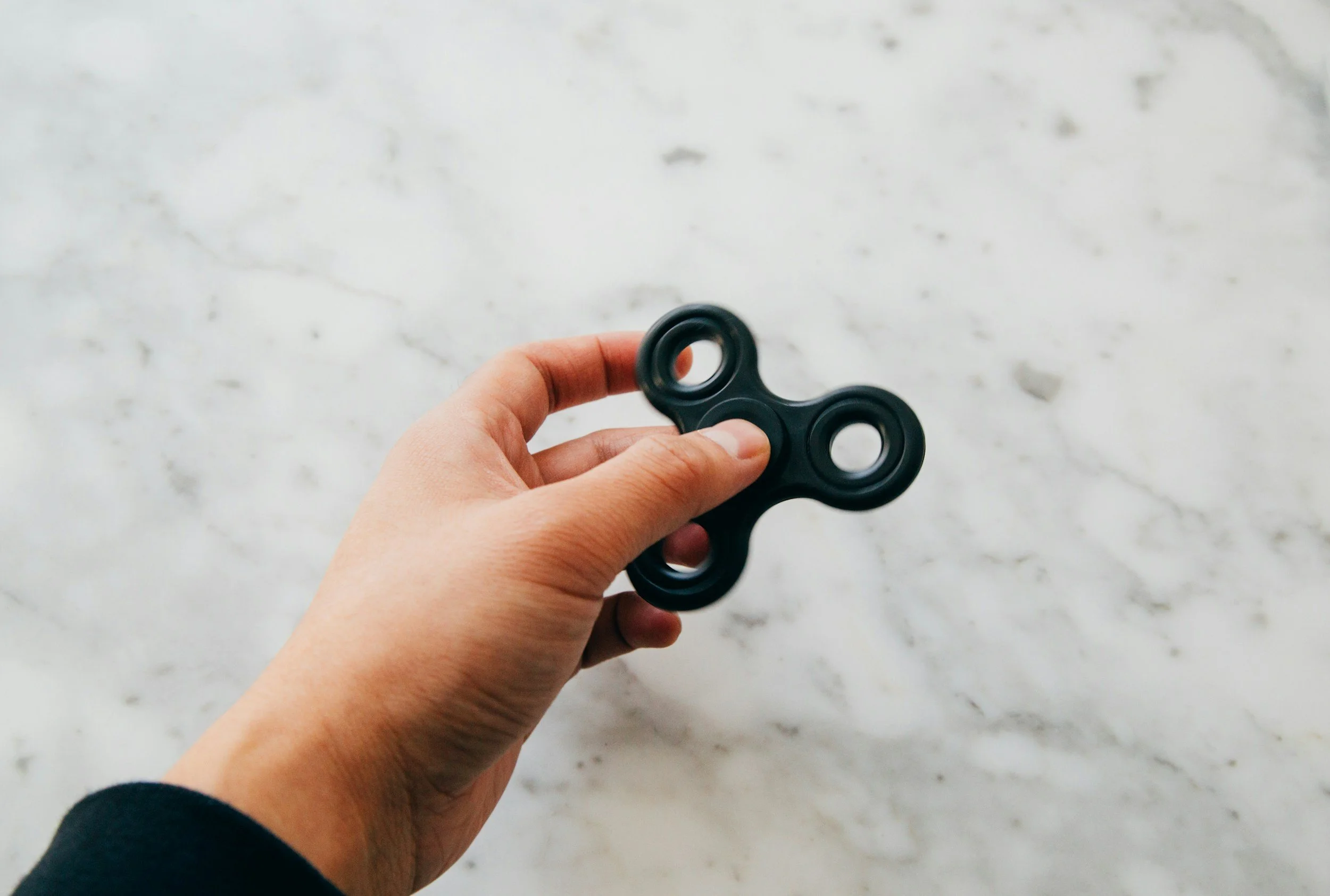 Photo of: Autistic teen holding a fidget spinner