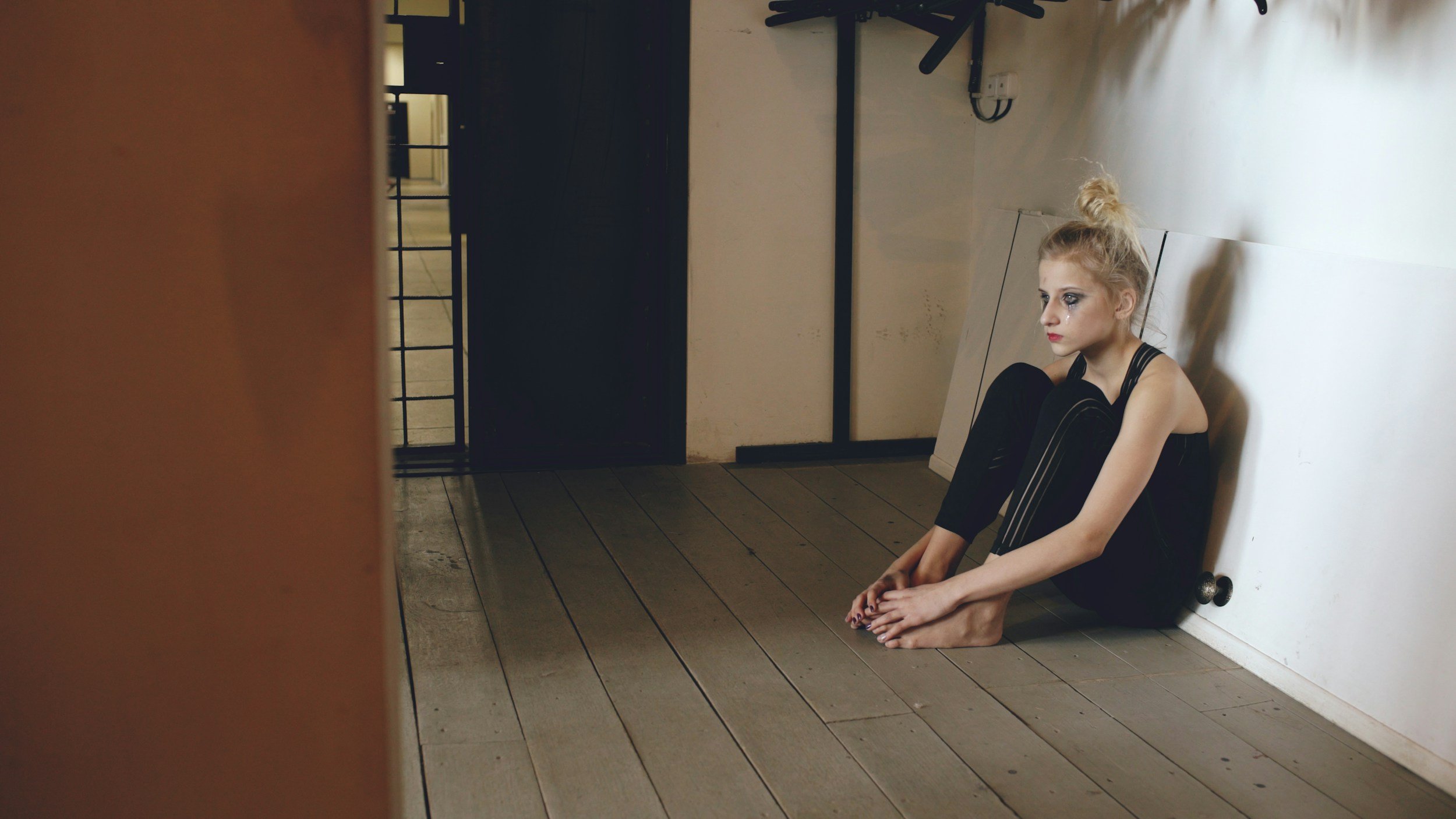 Autistic teen setting on the floor crying from heartbreak