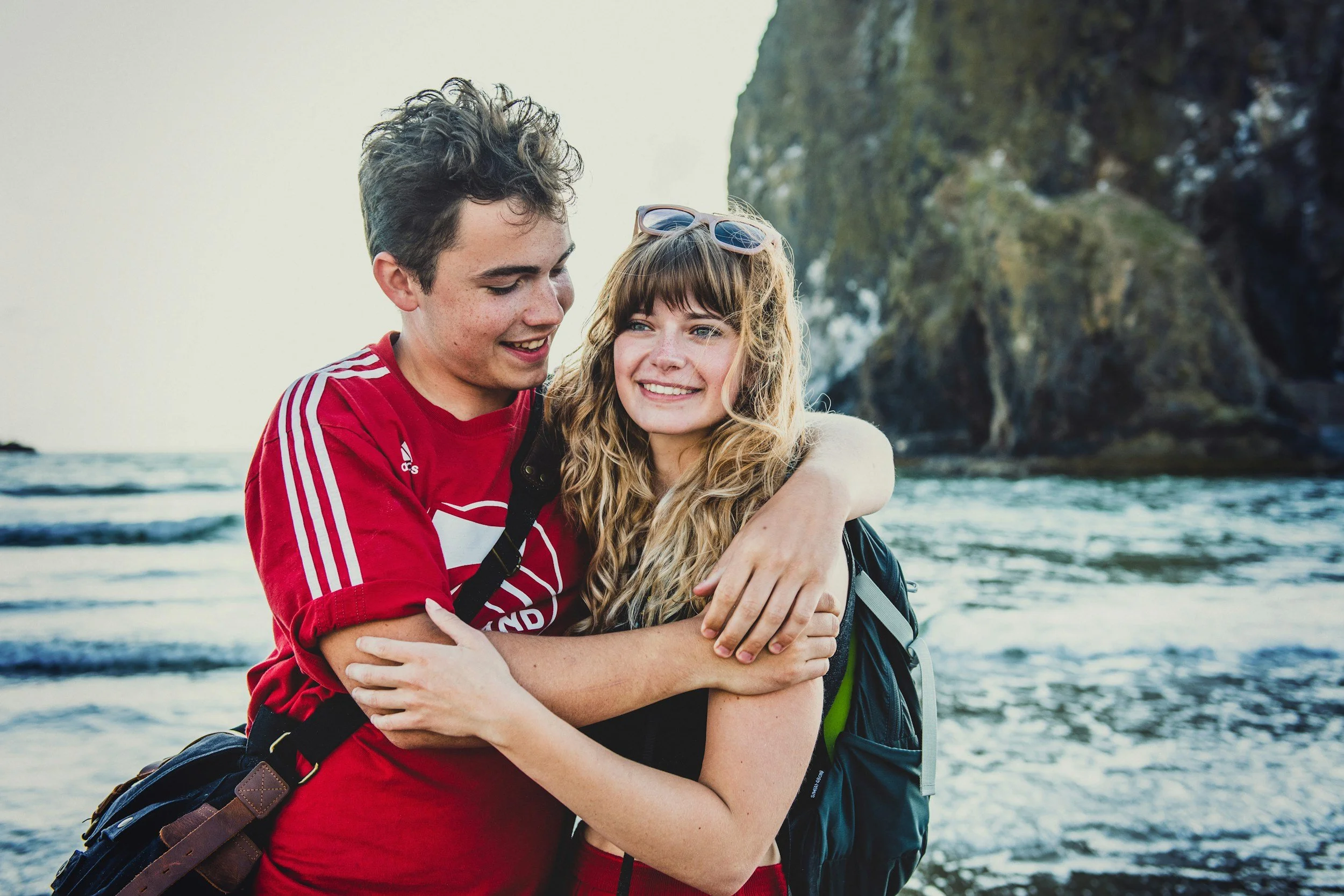 Autistic teens standing on the beach hugging