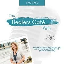 Book cover titled 'The Healers Café' featuring a woman with blonde hair, wearing a white blazer and smiling, with a light blue and white background.