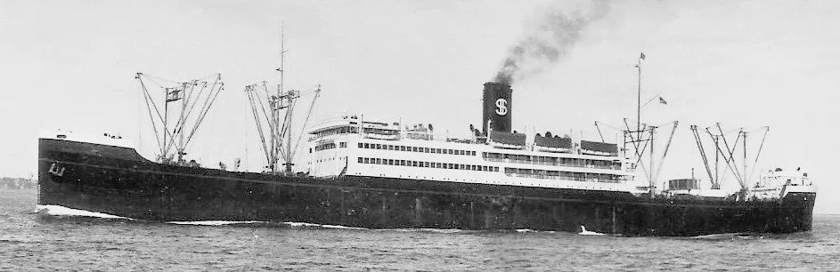 Black and white photo of an old steamship sailing on the ocean with smoke coming from the funnel.
