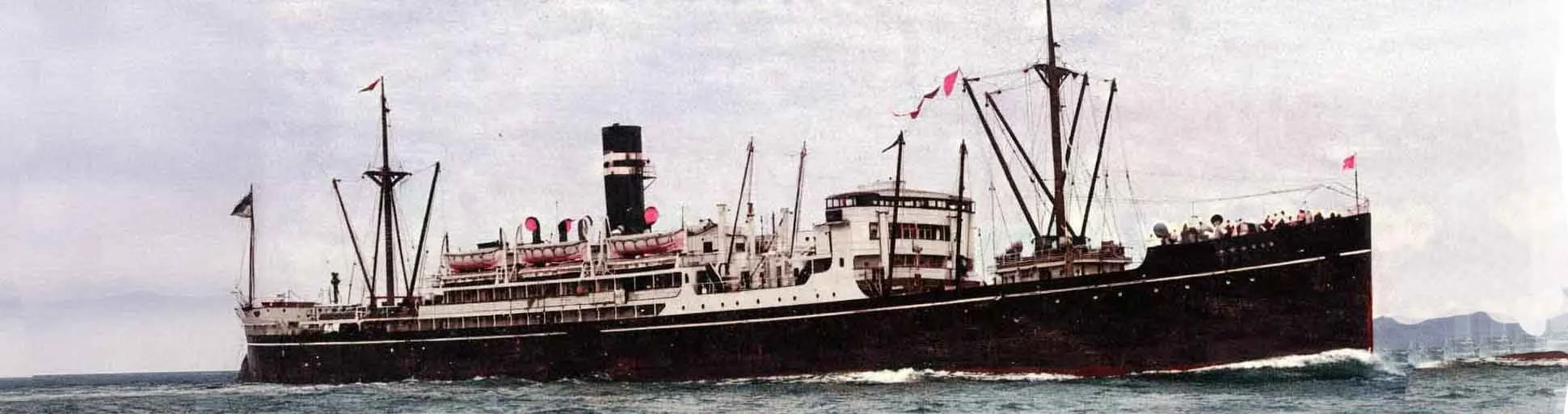 An old black and white passenger ship with a prominent smokestack sailing on the ocean.