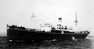 A black and white photo of a large early 20th-century cargo ship at sea.