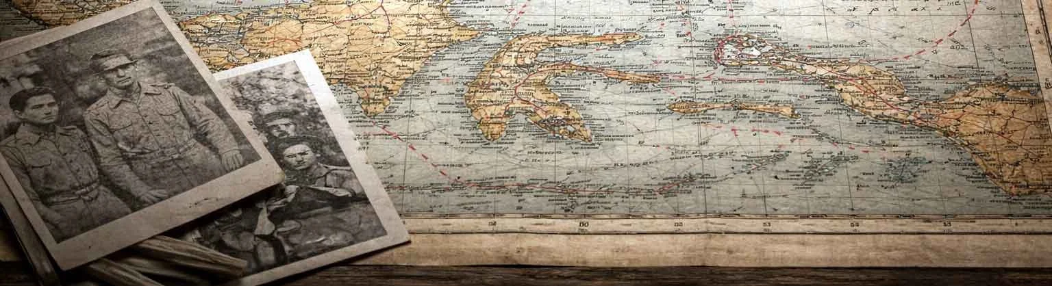 Vintage map of Italy on a wooden surface with black and white old photographs of soldiers placed on top.