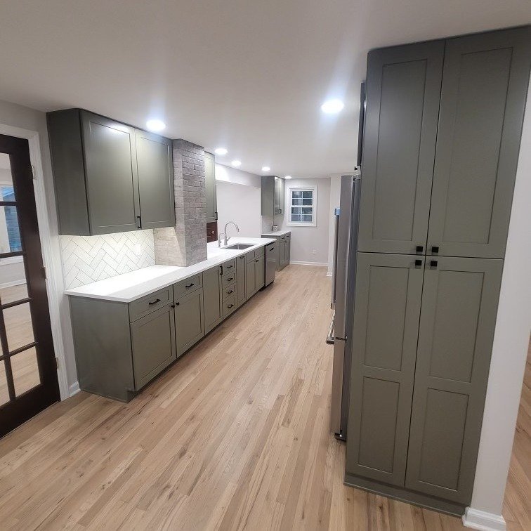 Full kitchen remodel with olive green cabinets, white countertops, and light hardwood floors – Tampa FL