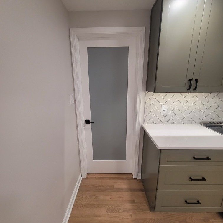 Frosted glass pantry door and green cabinetry with white tile backsplash – Clearwater FL