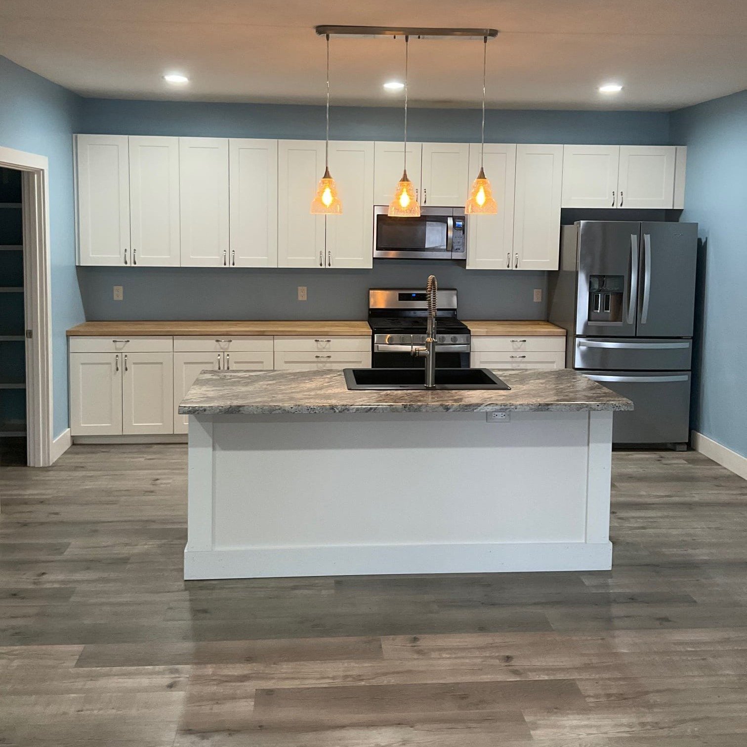 Full kitchen wall with white shaker cabinets and stainless steel appliances – Tampa kitchen remodel