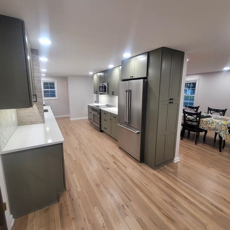 Modern green kitchen cabinets with white quartz and light wood flooring – Clearwater handyman remodel