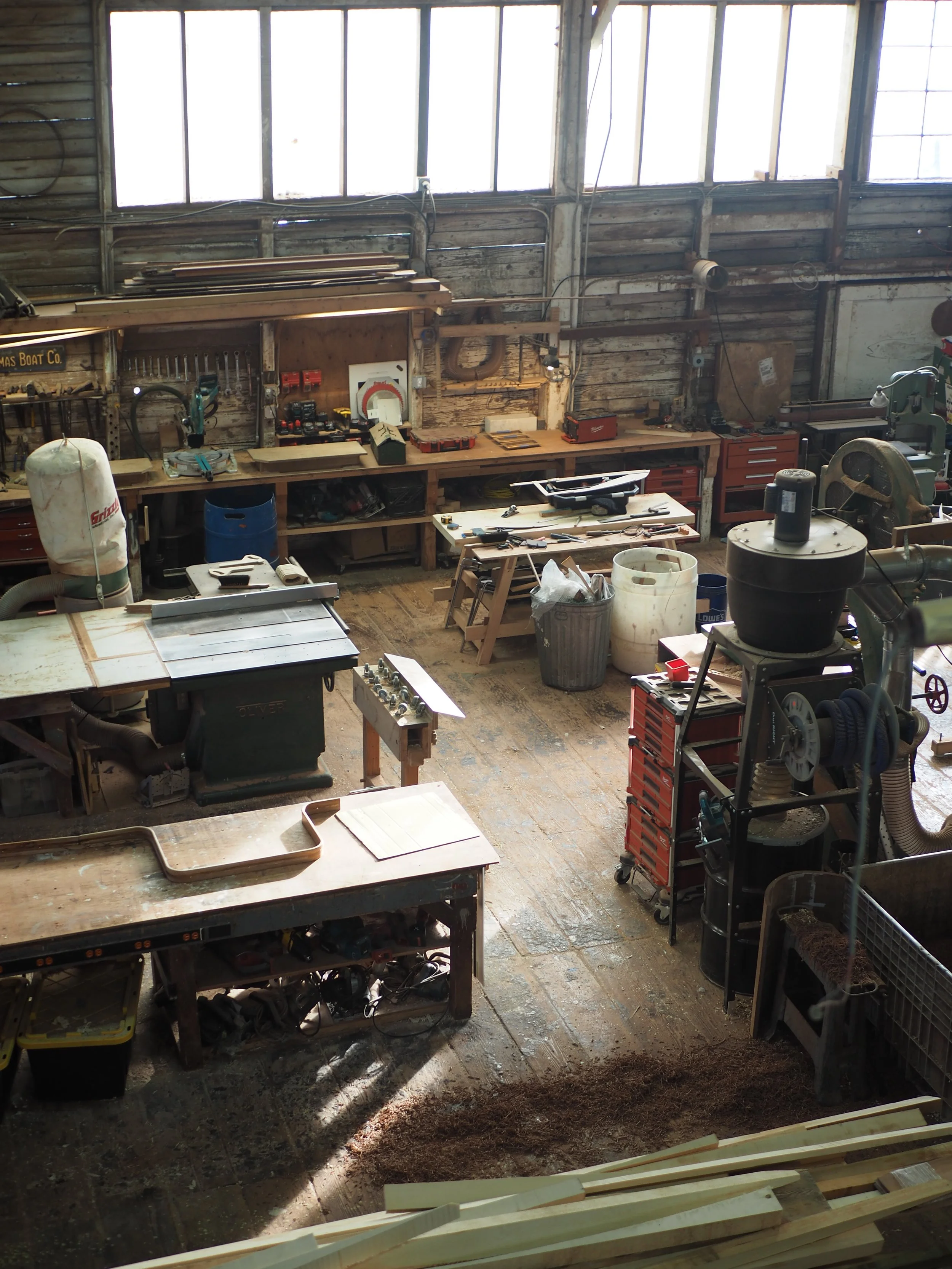 Woodshop in diffuse light including workbenches and machinery