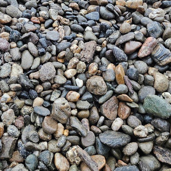 Close-up of multicolored gravel stones on the ground.