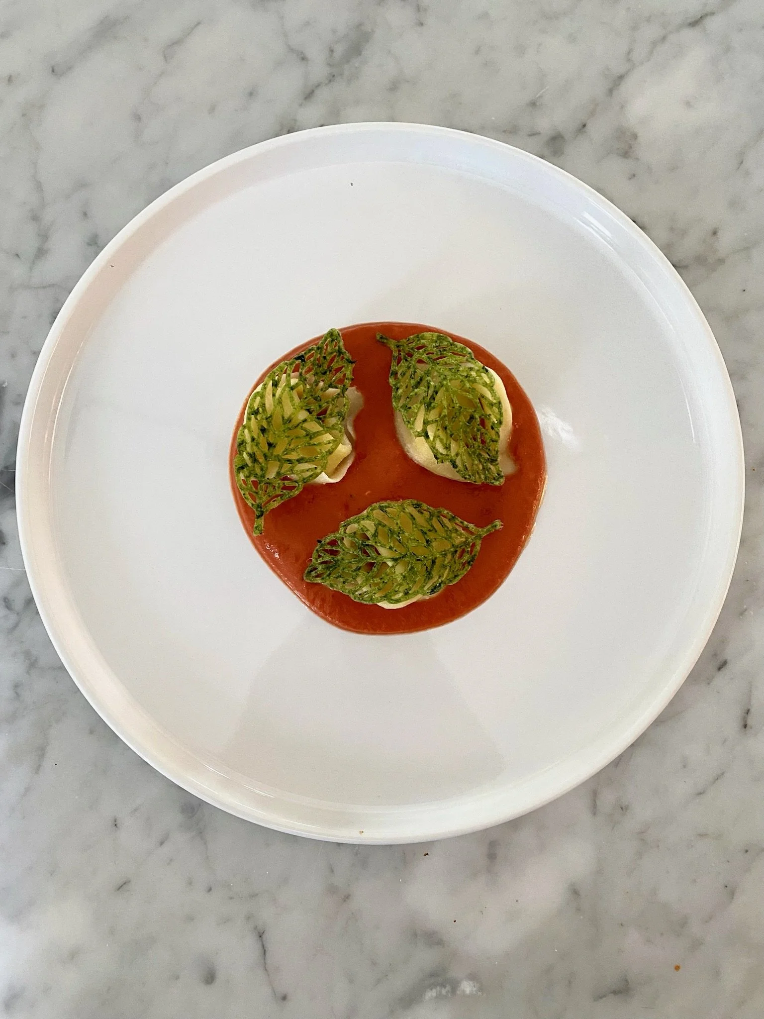Procuitto Ricotta tortellini with romesco and spinach tuile