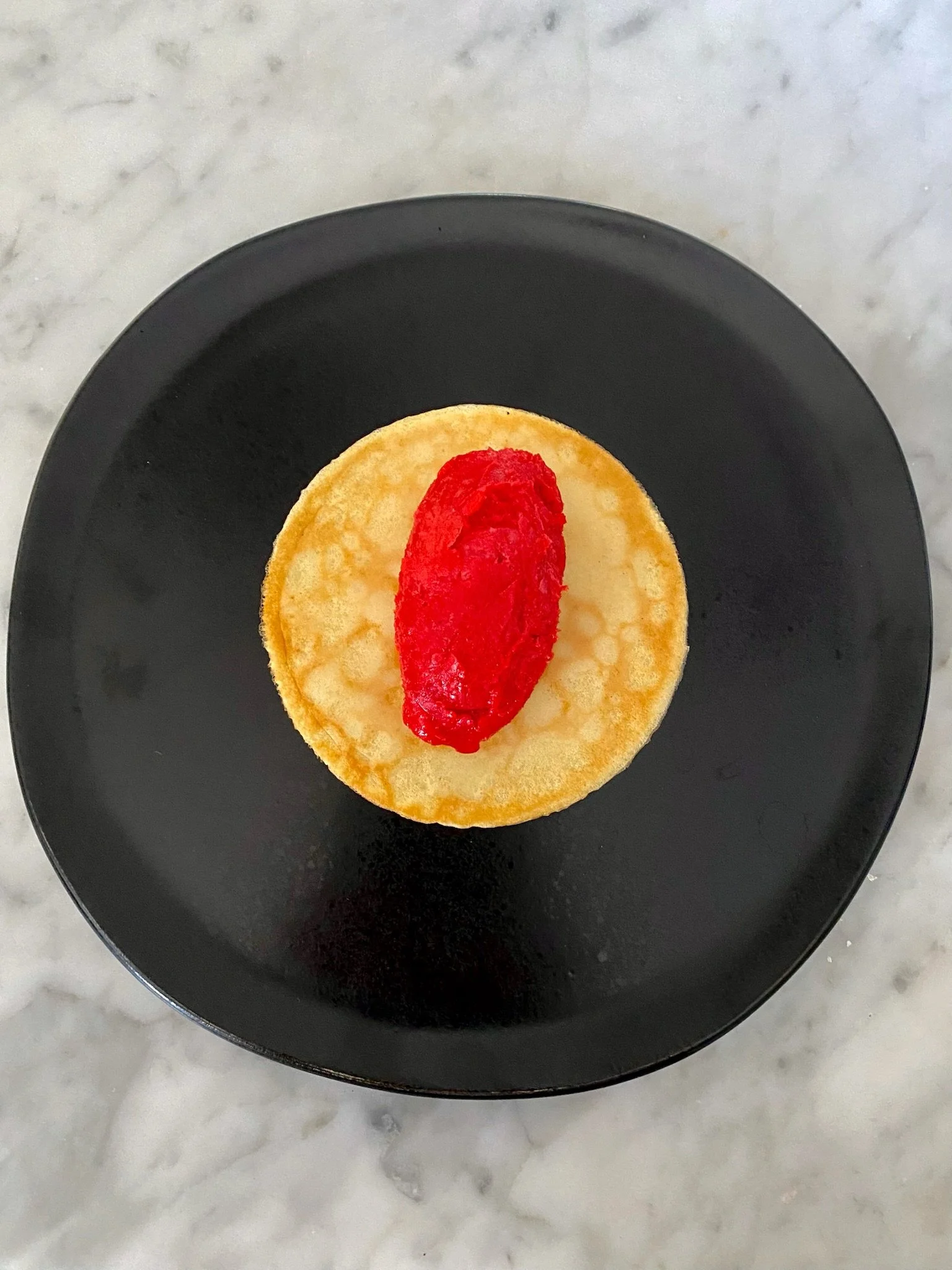Raspberry sorbet quenelle on white chocolate almond crepe