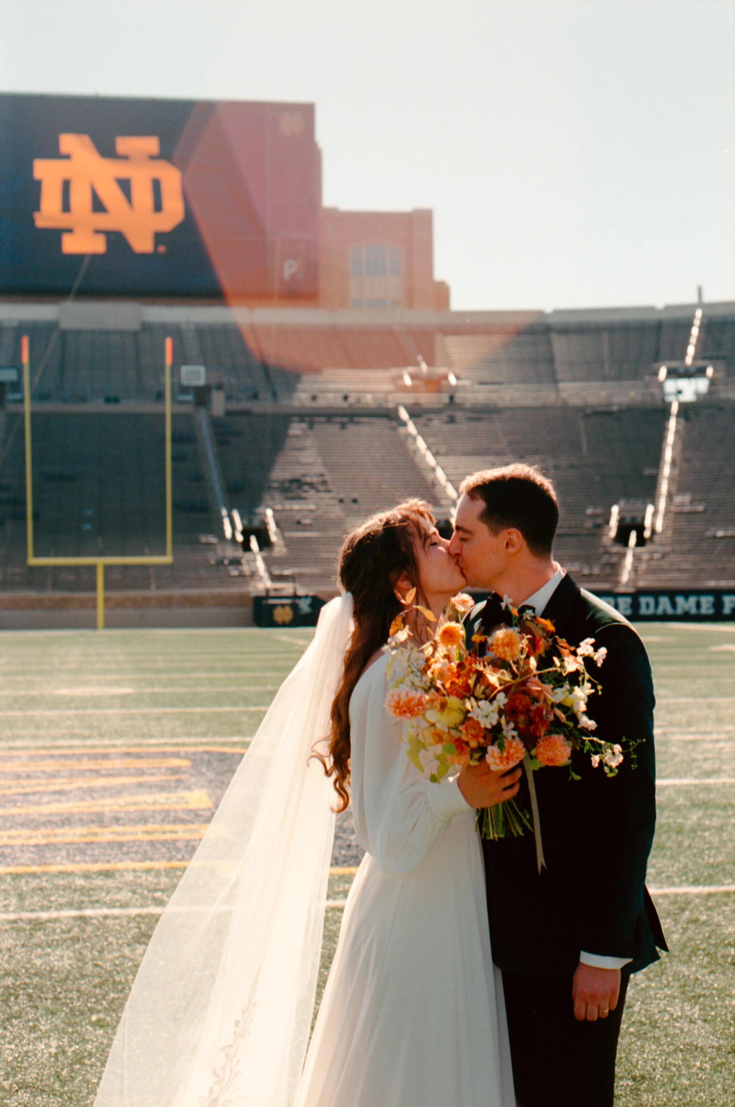 LBW48-wedding-couple-kissing-notre-dame-football-stadium.jpg
