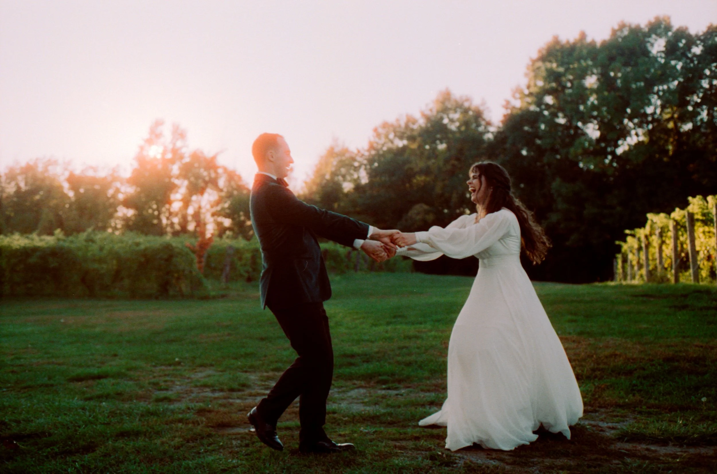 LBW110-bride-groom-spinning-laughing-on-grass-at-sunset.jpg
