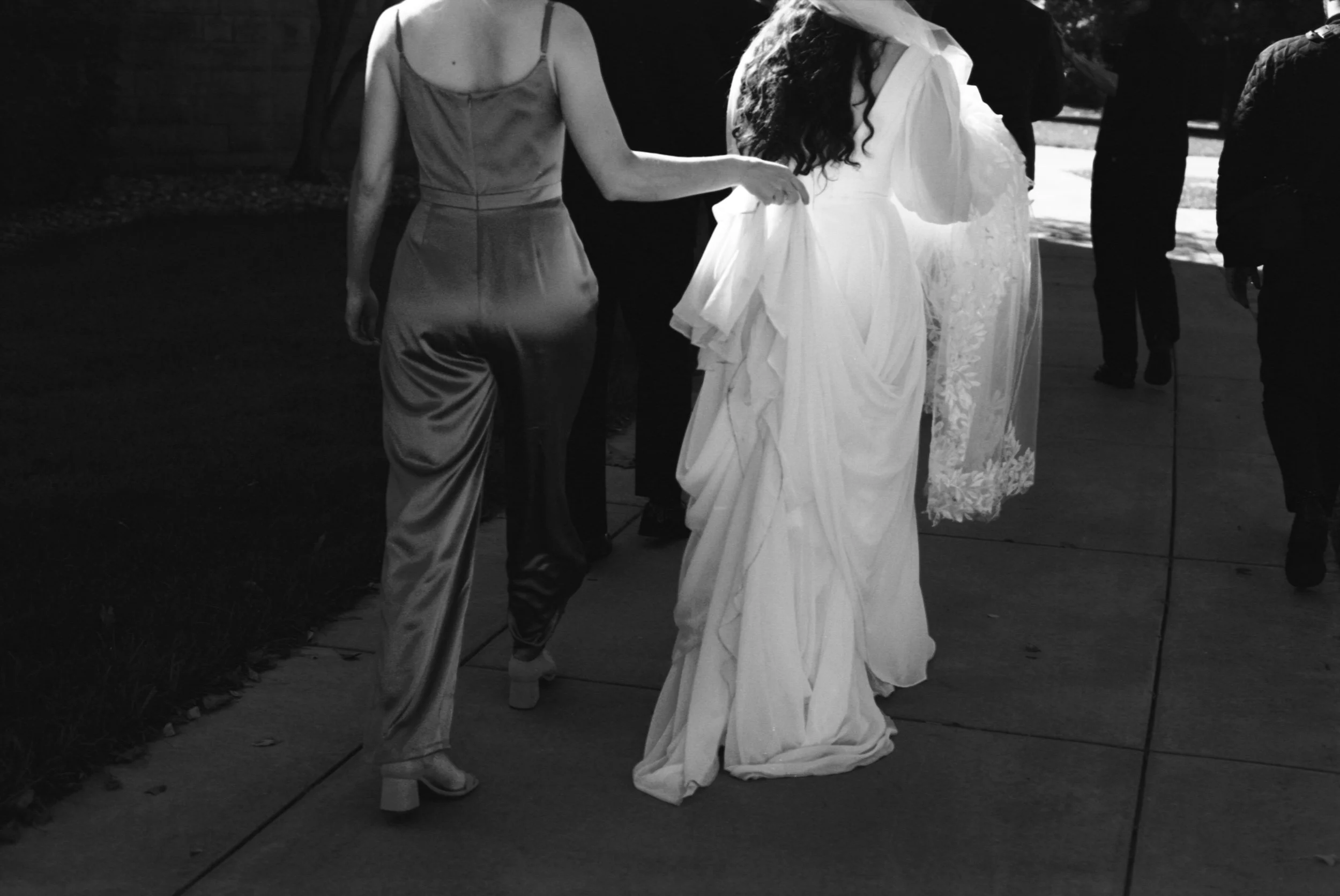 LBW33-bridesmaid-carrying-brides-dress.jpg