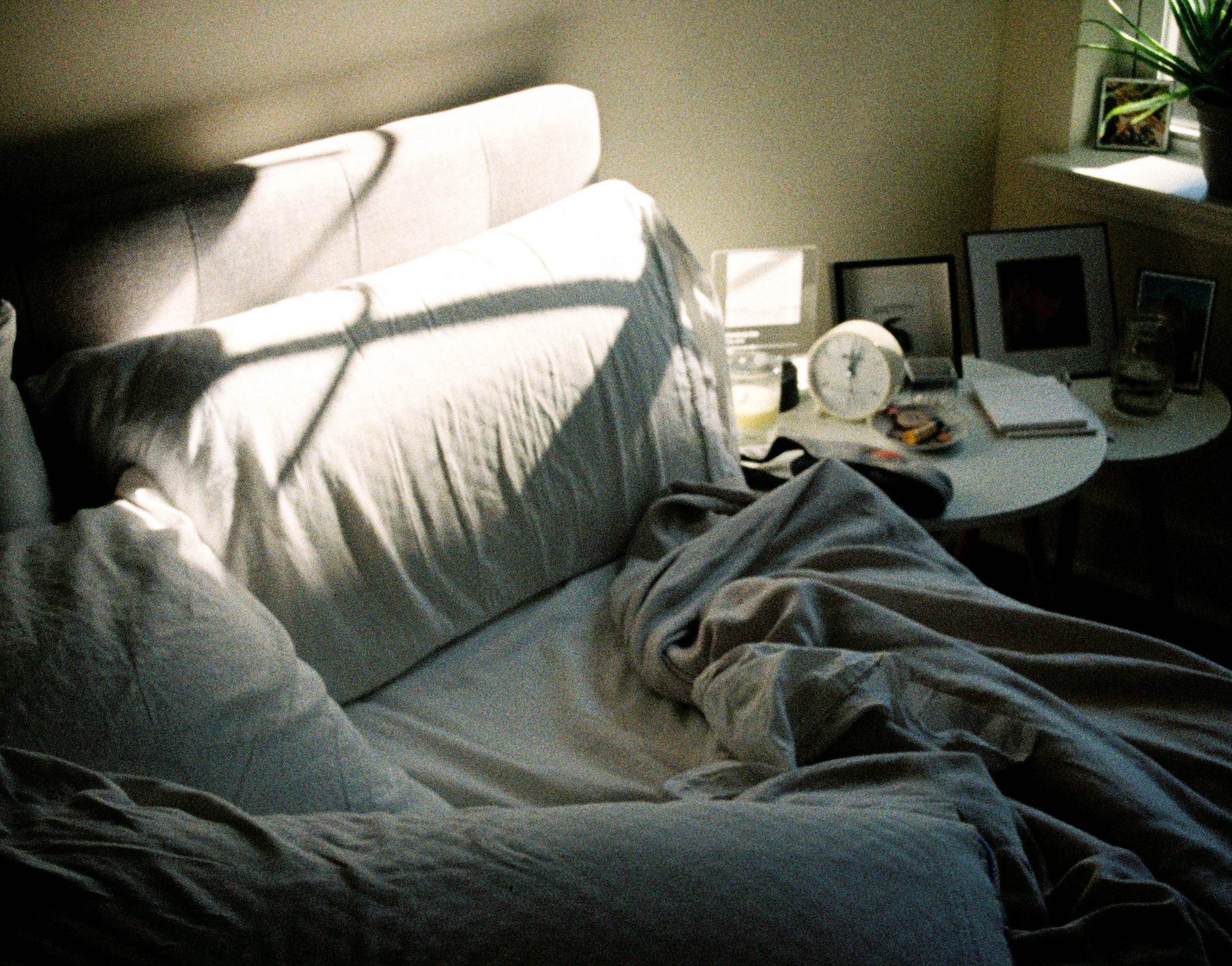 bed-sheets-in-sunlight-nightstand-alarm-clock-pillow.jpg