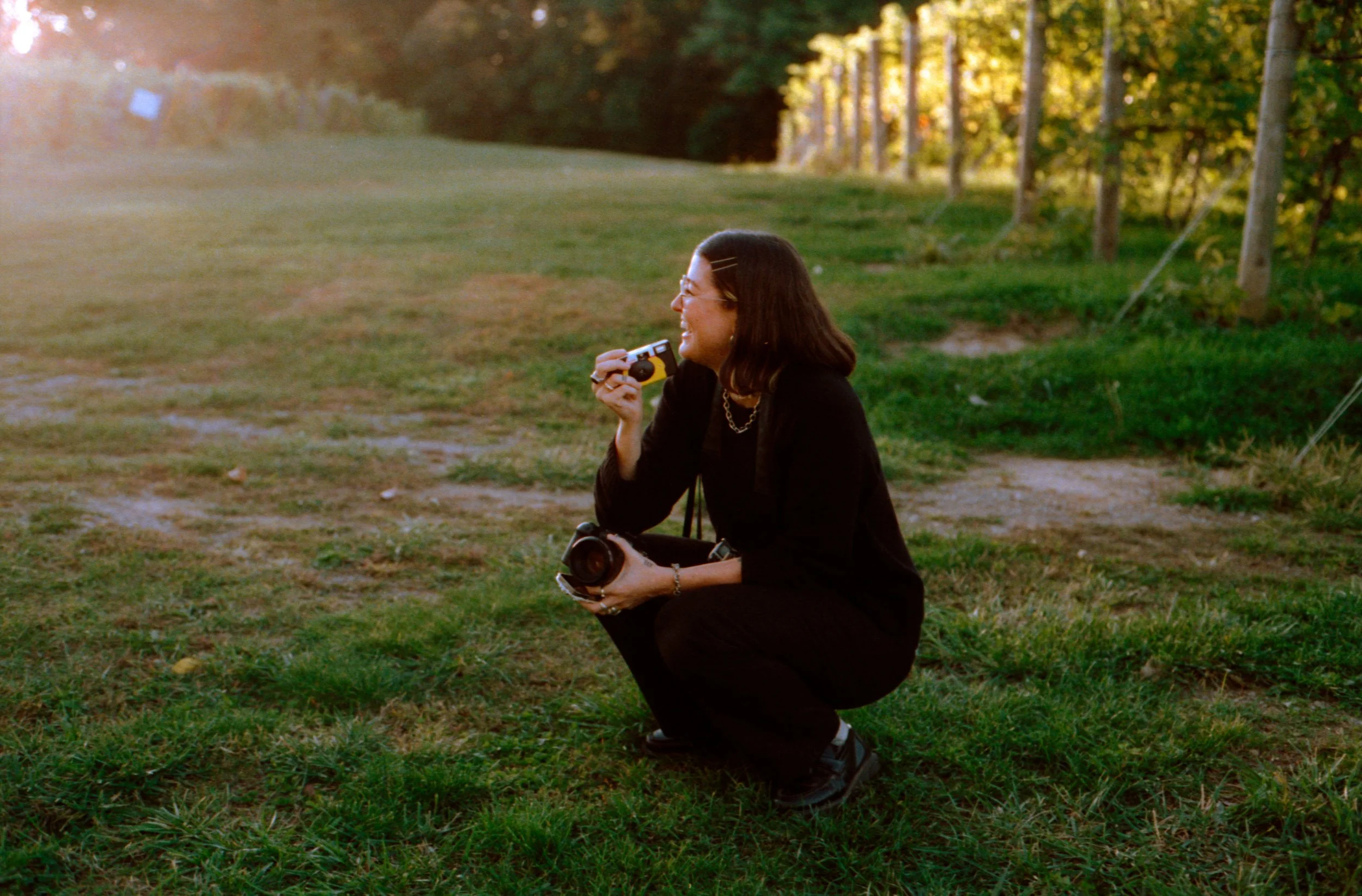 LBW107-wedding-photographer-laughing-crouched-on-grass.jpg