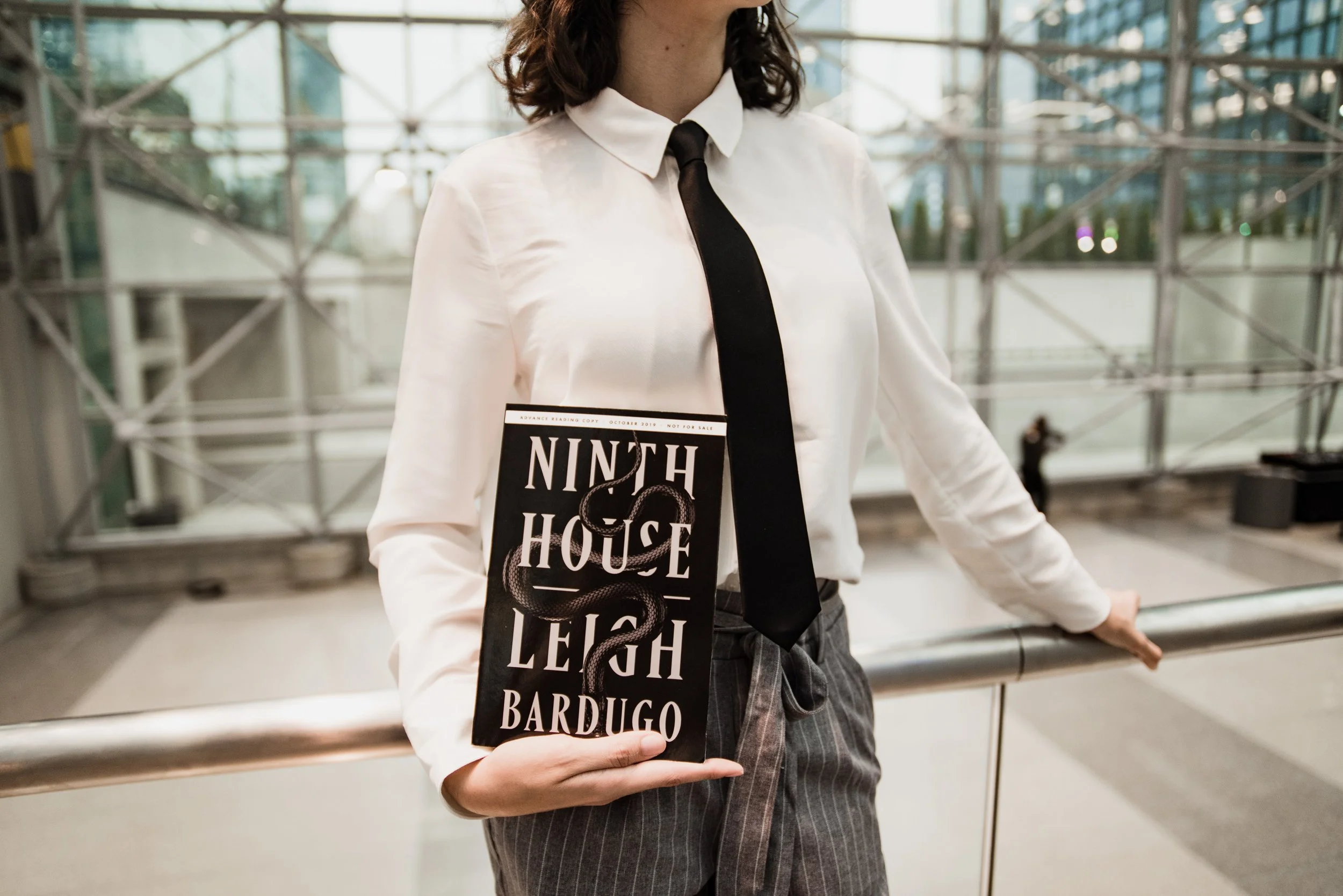 BT270-woman-in-suit-holding-ninth-house-book.jpg