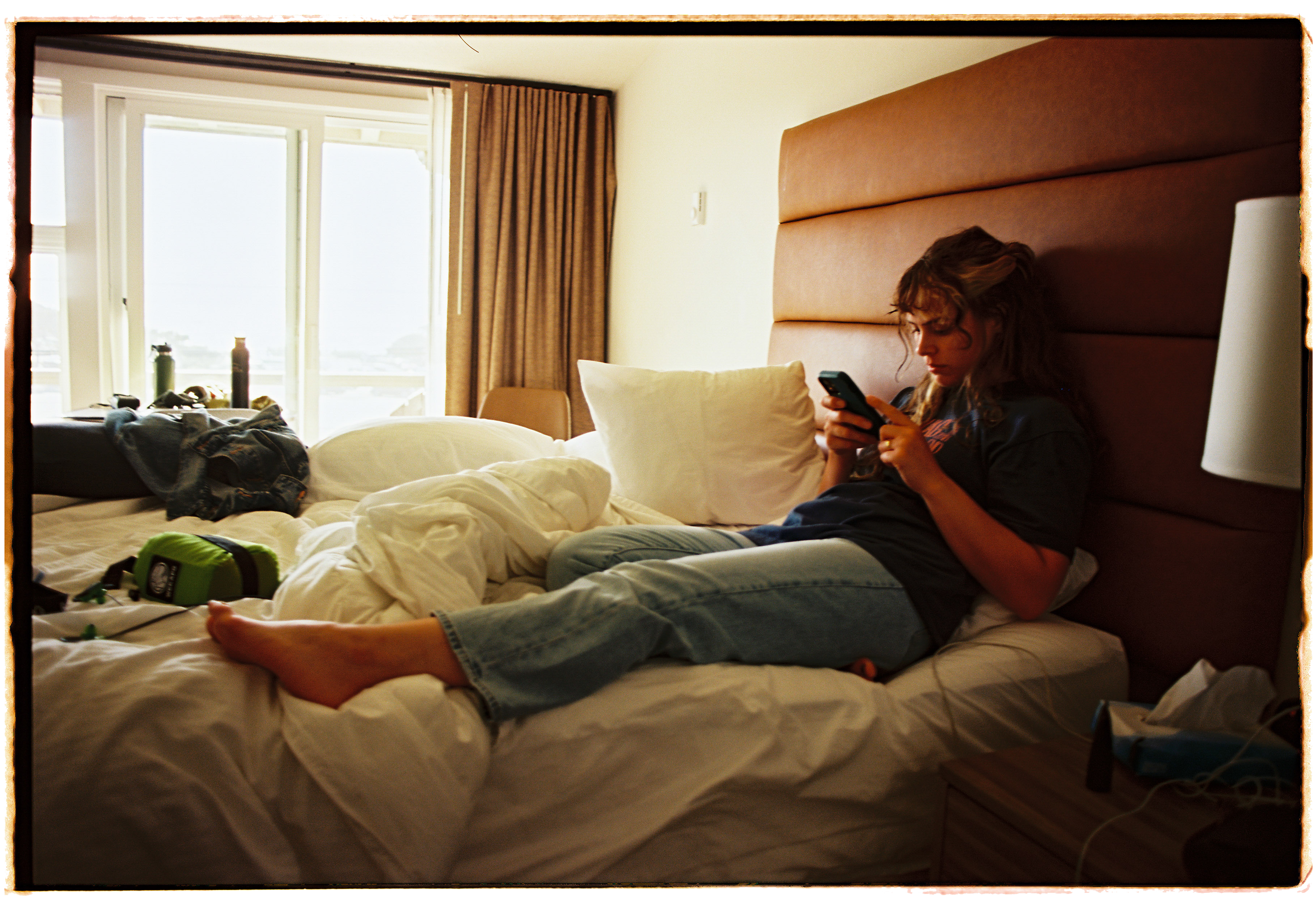 pnw48-woman-sitting-on-hotel-bed.png