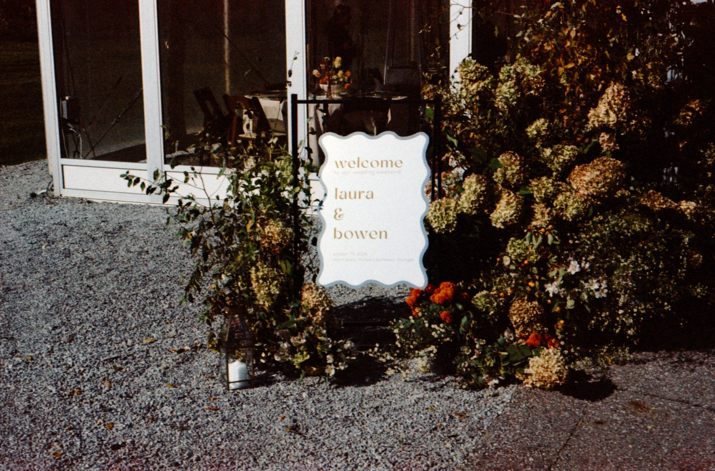 LBW55-wedding-reception-entry-sign-surrounded-by-flowers.jpg