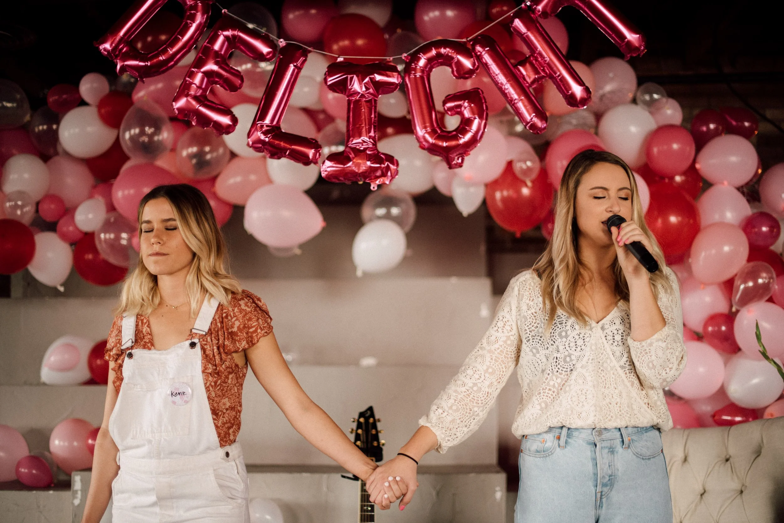 d214-women-microphones-holding-hands-praying-conference.jpg