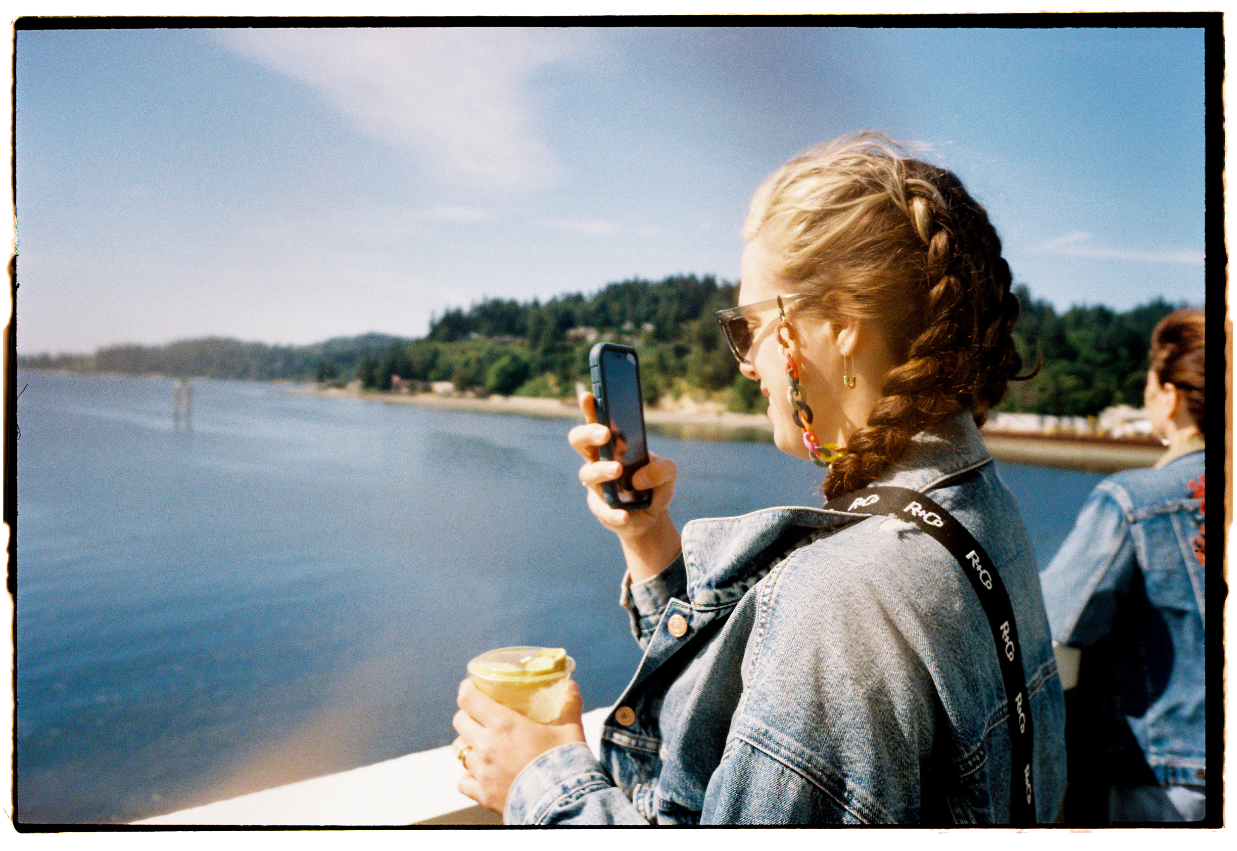 pnw214-woman-on-seattle-ferry-with-latte-and-iphone-in-braids.png