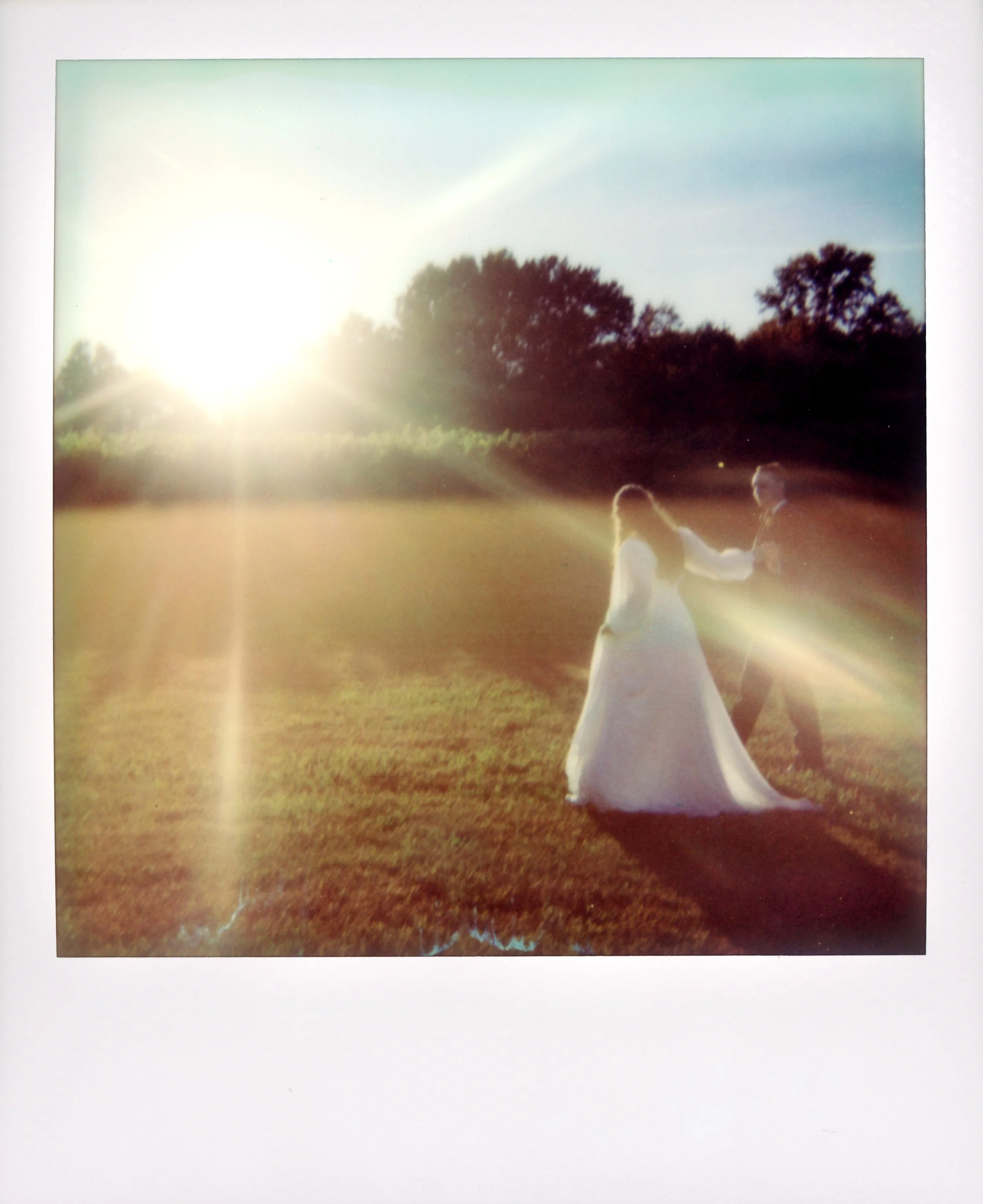 LBW94-wedding-couple-walking-through-grass-polaroid.jpg