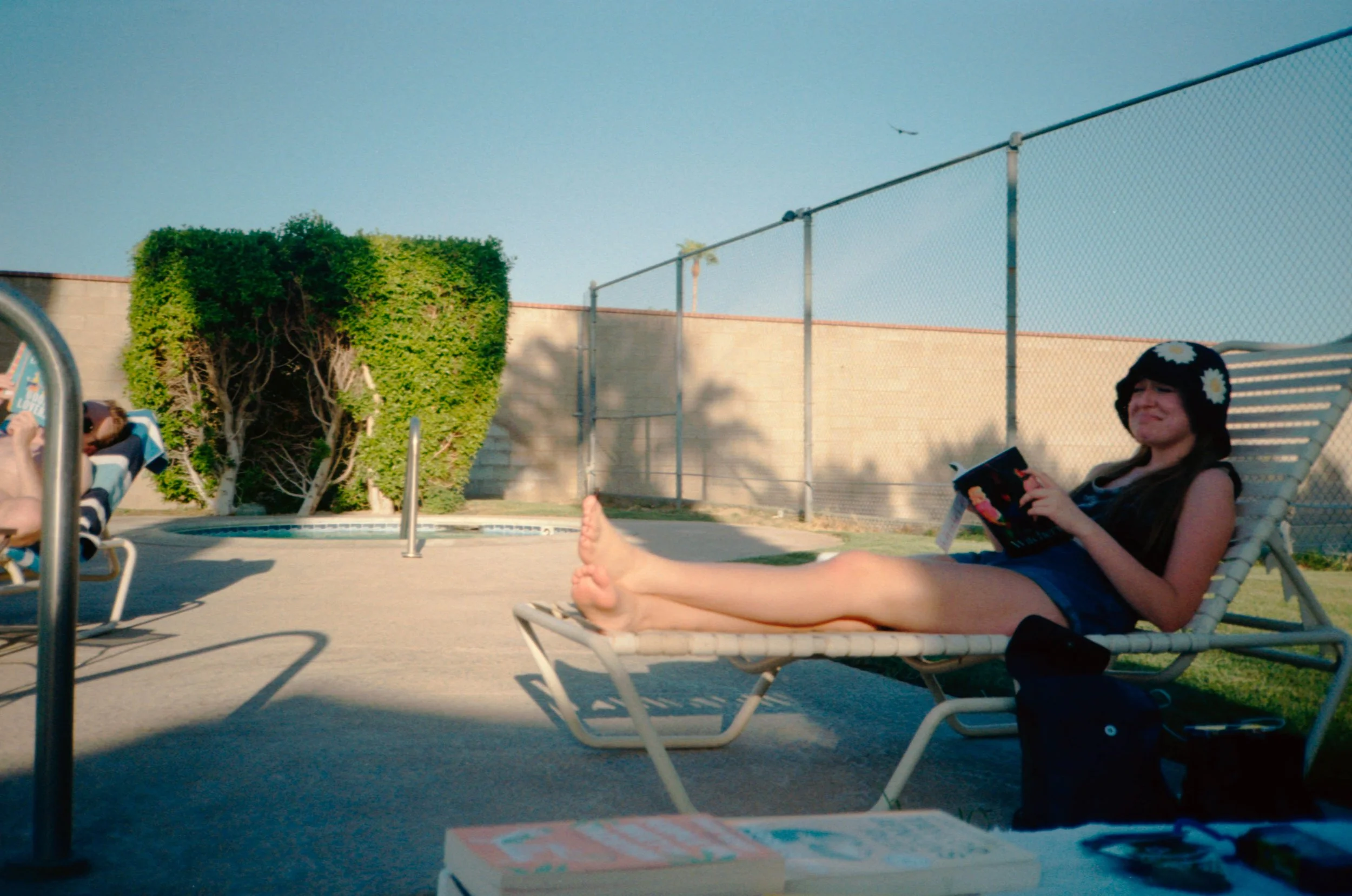 BT67-woman-frowning-reading-book-at-pool.jpg
