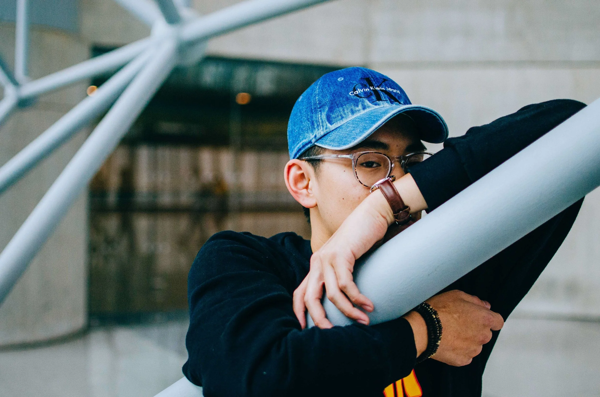 BT216-asian-man-ball-cap-leaning-on-railing.jpg