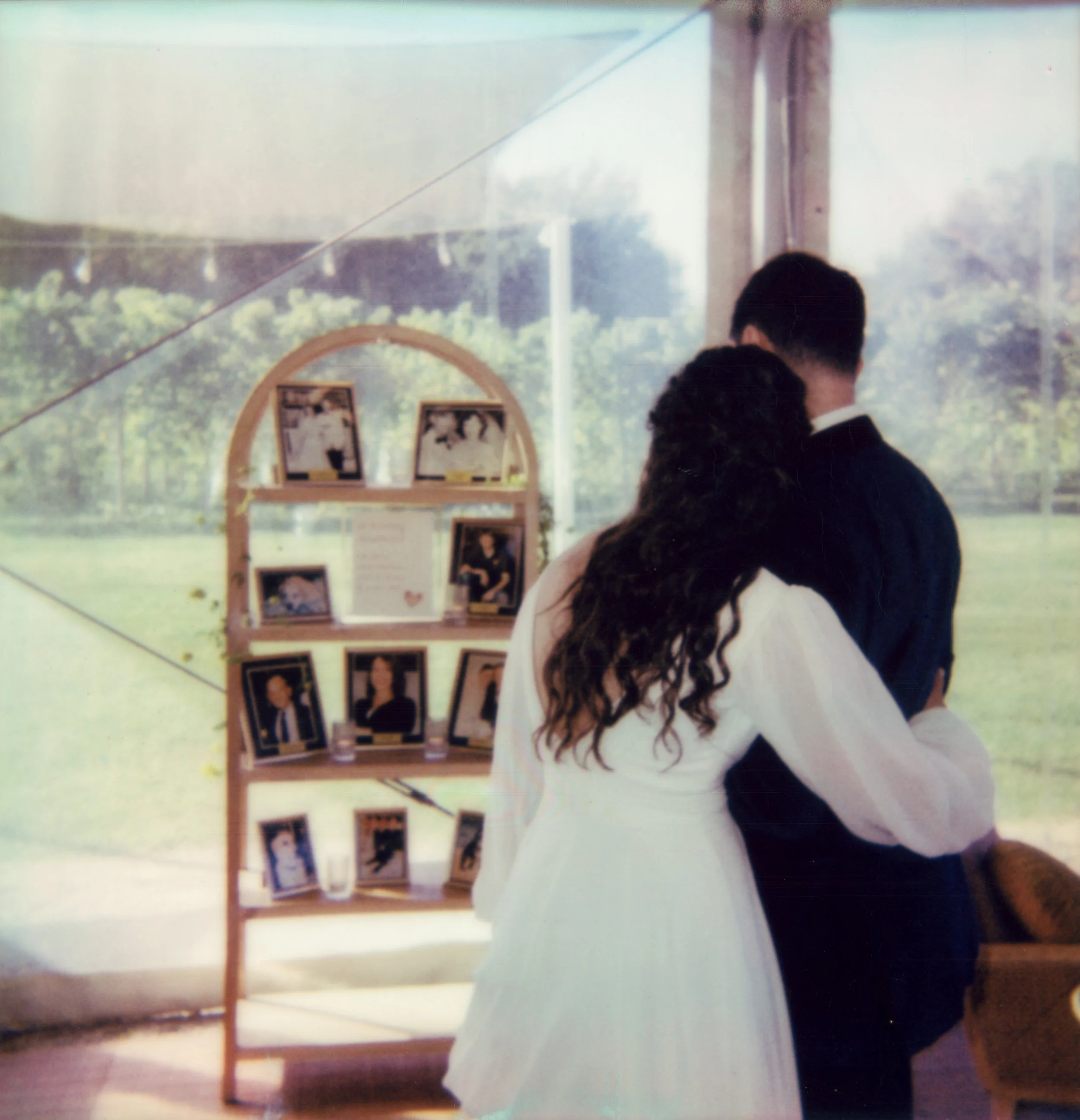 LBW81-bride-hugging-groom-looking-at-family-photos.jpg