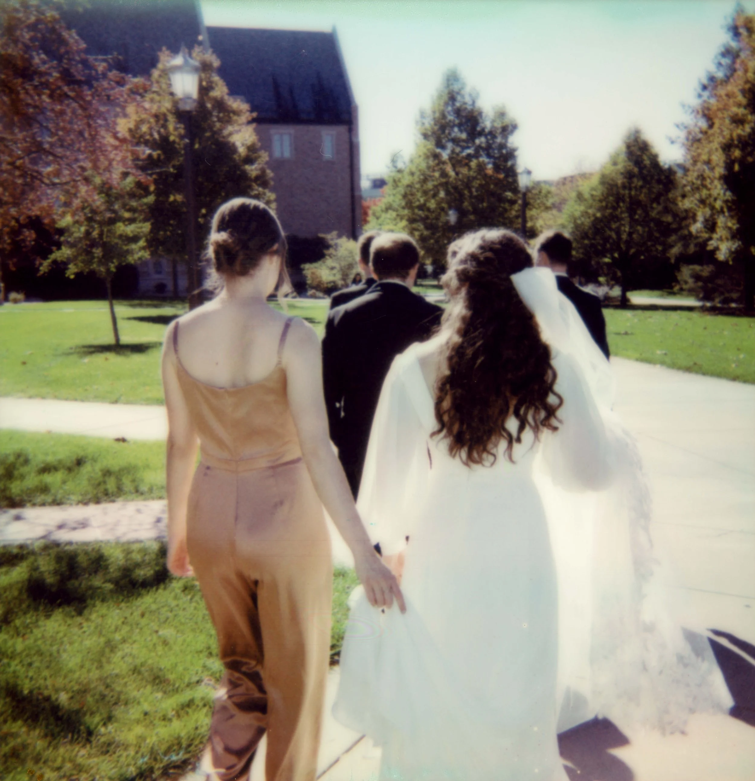 LBW31-bridesmaid-in-jumpsuit-helping-bride-walk.jpg