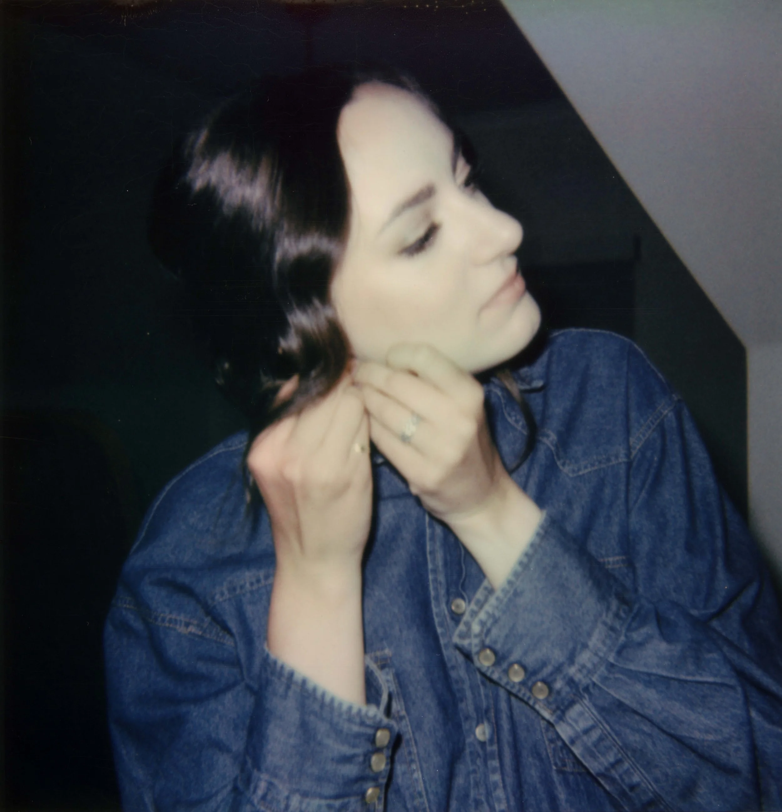 LBW7-brunette-woman-putting-in-earring-denim-shirt.jpg