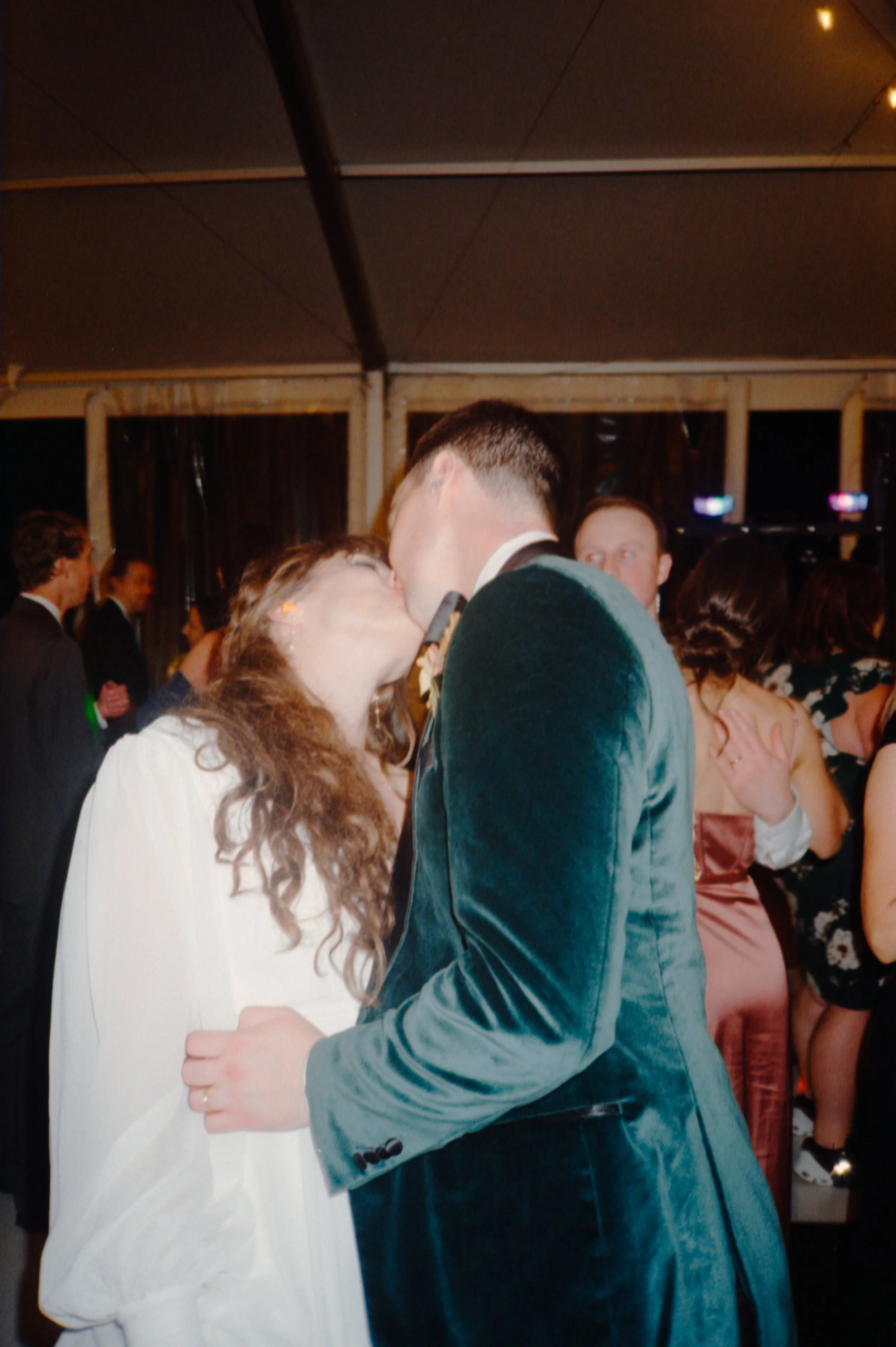LBW128-bride-groom-kissing-at-wedding-reception.jpg