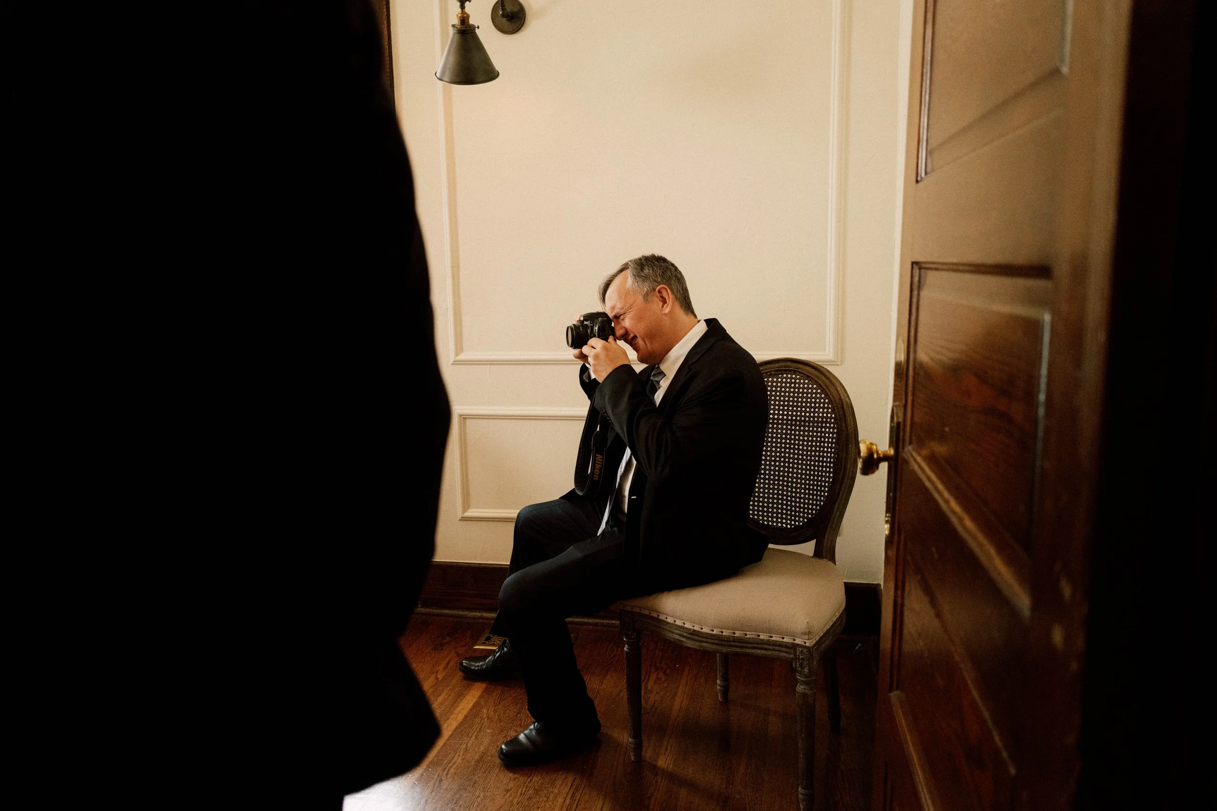 HRD15-man-in-suit-taking-picture-with-camera.jpg