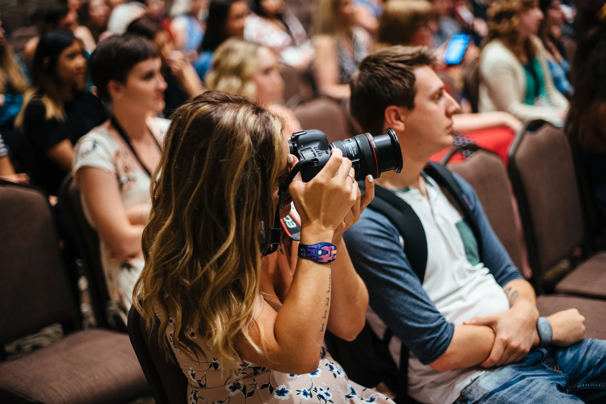 BT129-woman-in-crowd-taking-photos-on-camera.jpg