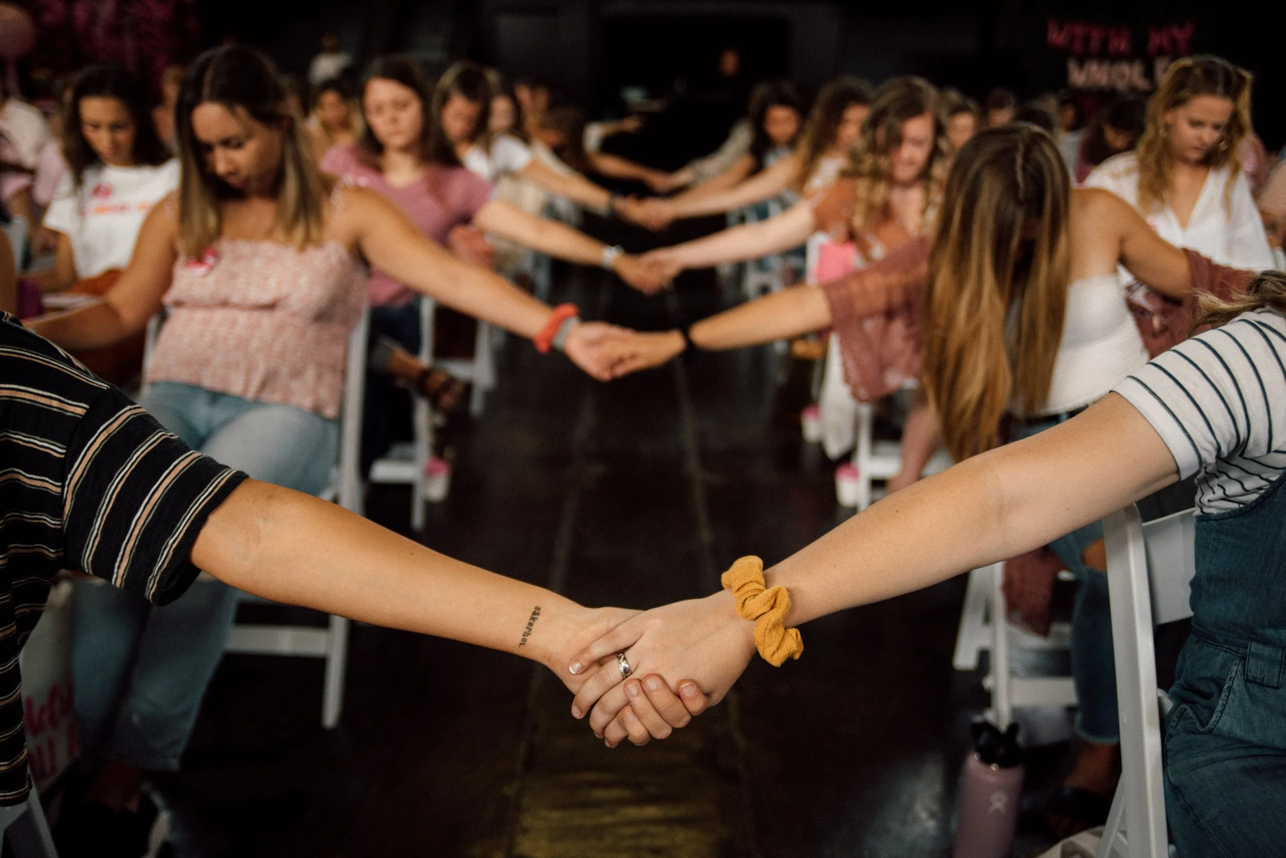 d283-women-praying-holding-hands-conference.jpg