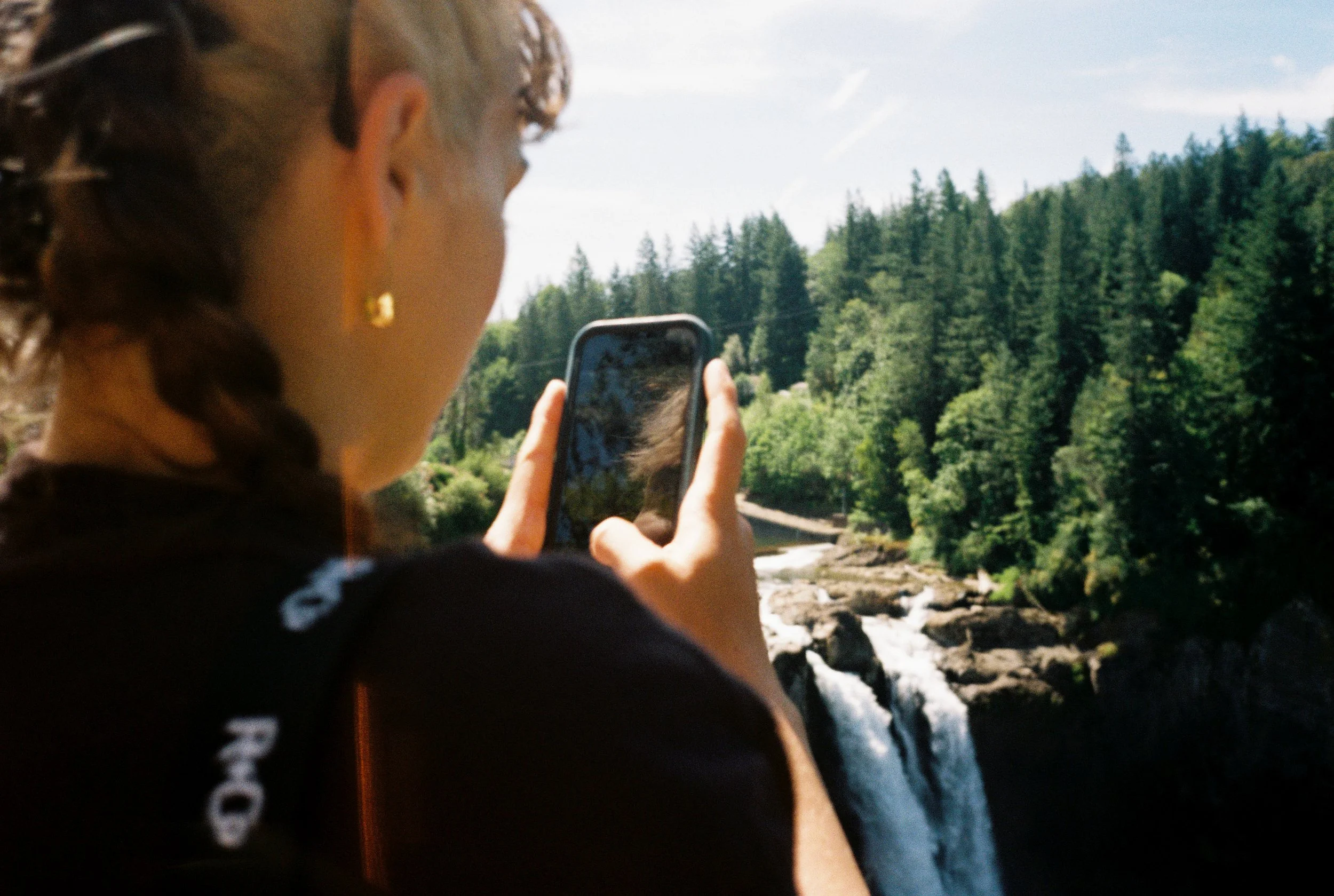 pnw220-woman-taking-photo-on-iphone-of-waterfall.jpg