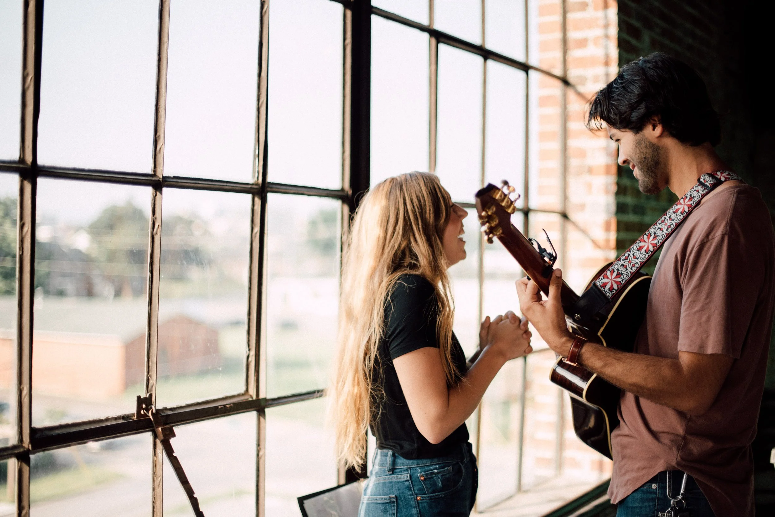 d208-man-woman-practicing-guitar-singing-window.jpg