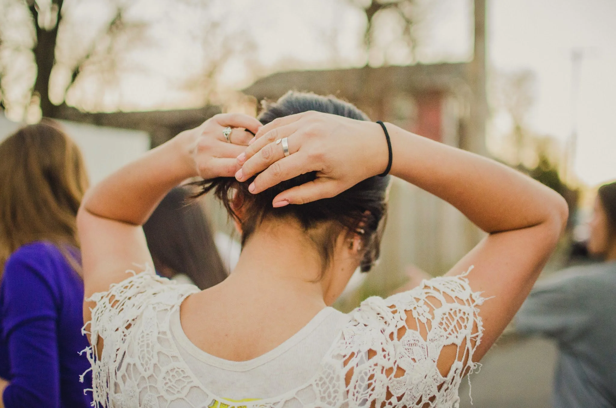 d13-woman-fixing-hair-white-top.jpg