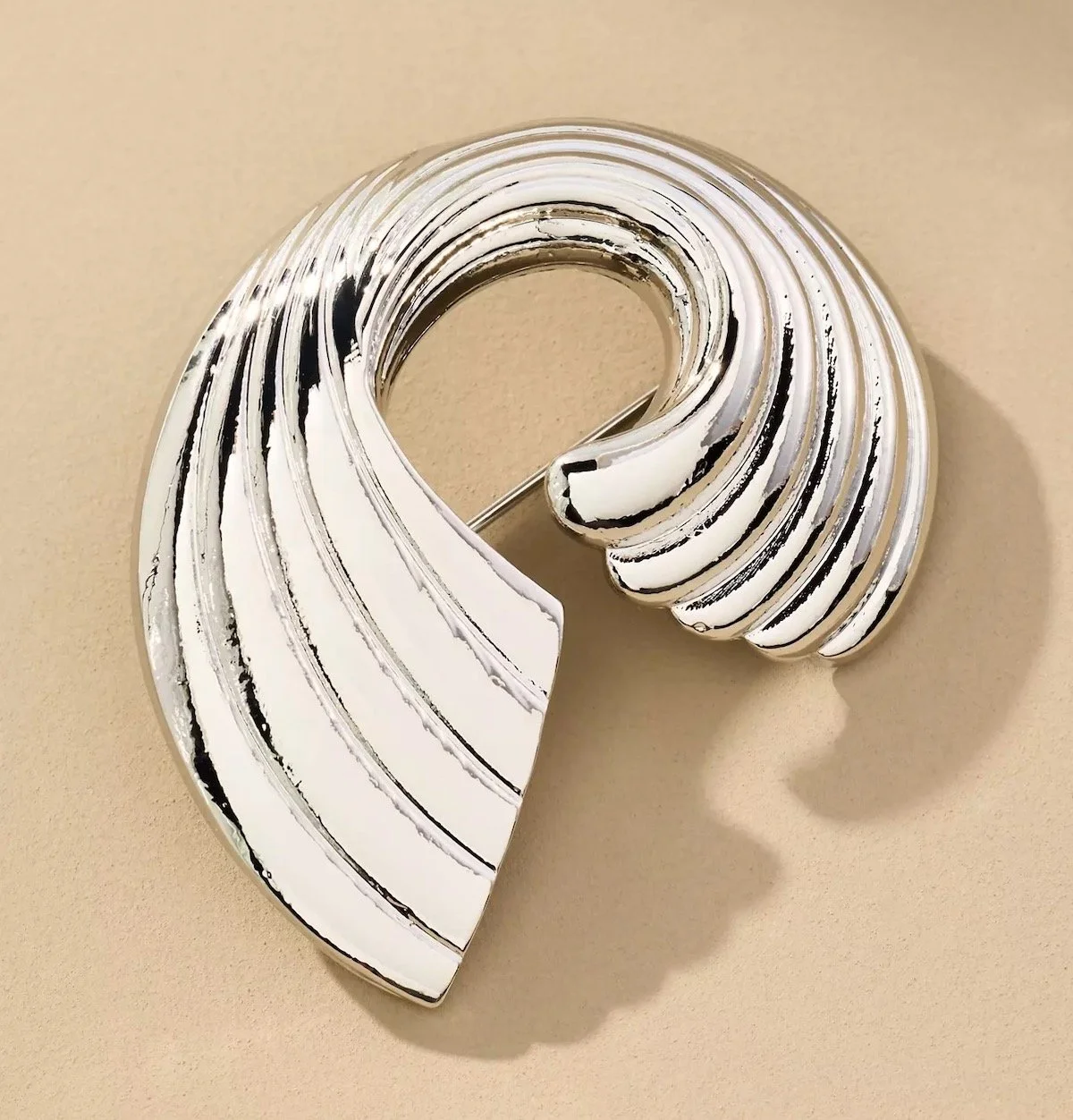 By Anthropologie Ribbed Swirl Brooch in Silver, $22.95 at Anthropologie