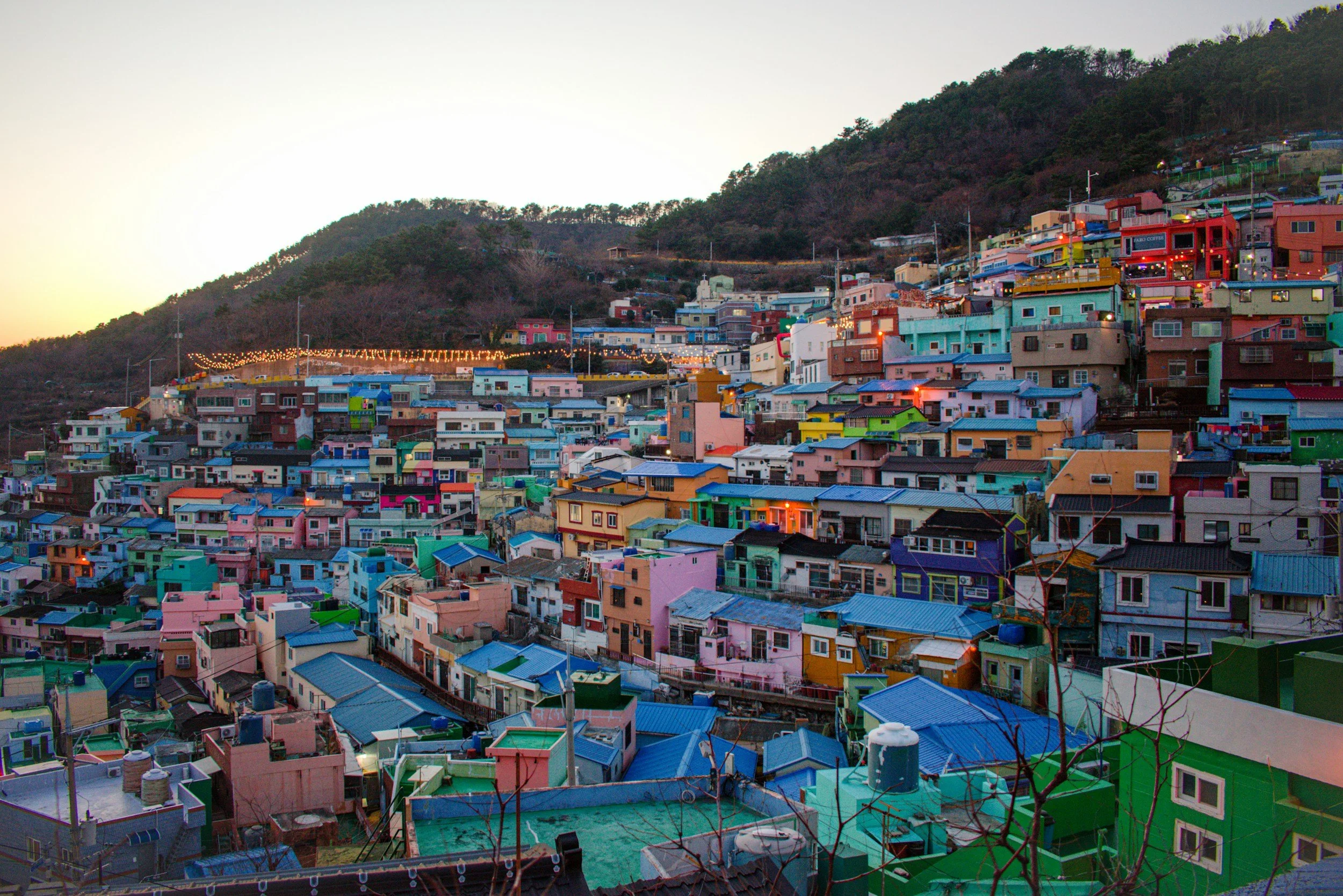 Colorful houses on a hillside at sunset.