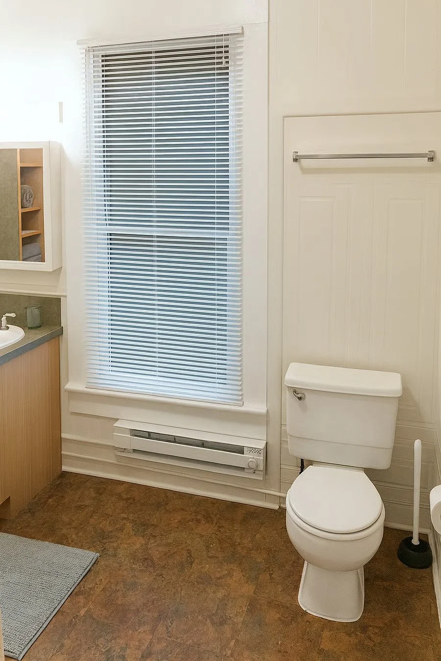 Bright bathroom with storage and clean finishes for daily conveniences.