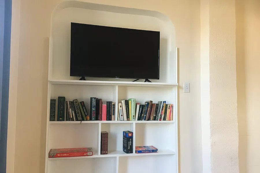 Smart TV with built-in shelving and books, creating a cozy and practical space for evenings at home.