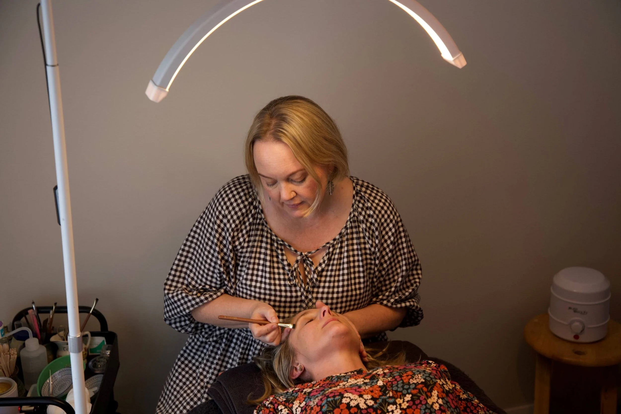 Beautician Ylonda Marshall shaping a client's eyebrows during a treatment.jpg