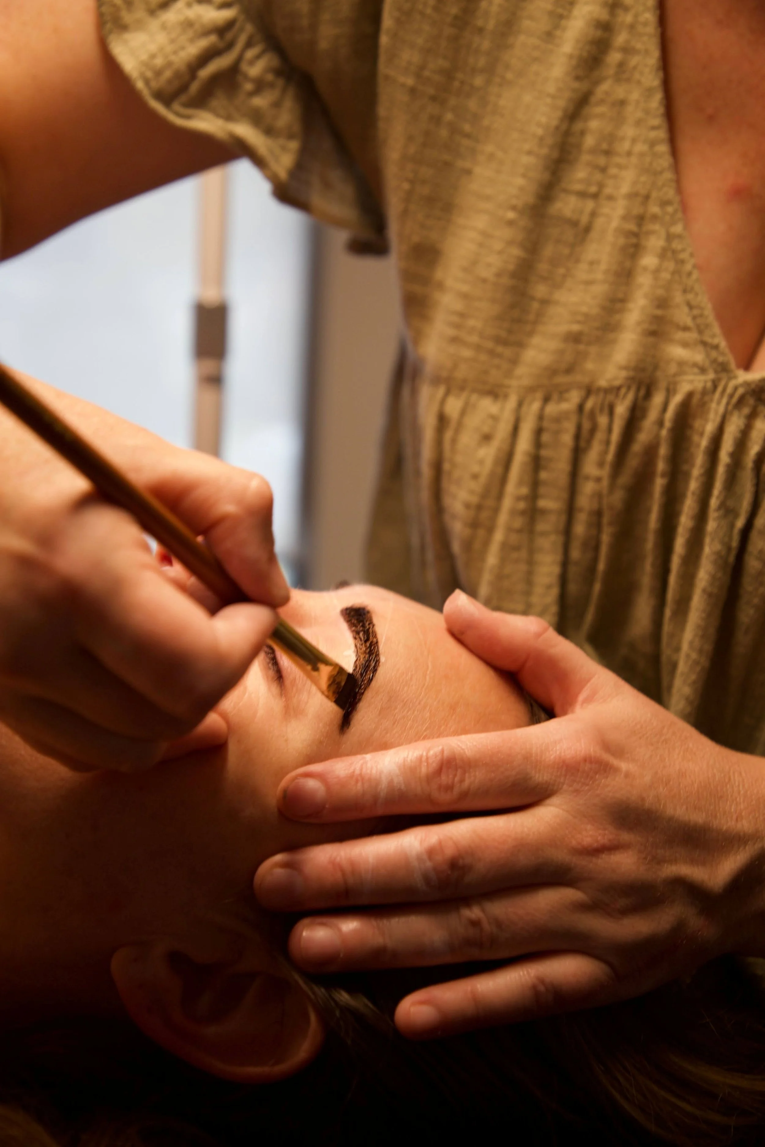 Lonnie giving a woman an eyebrow wax shape and tint.jpg
