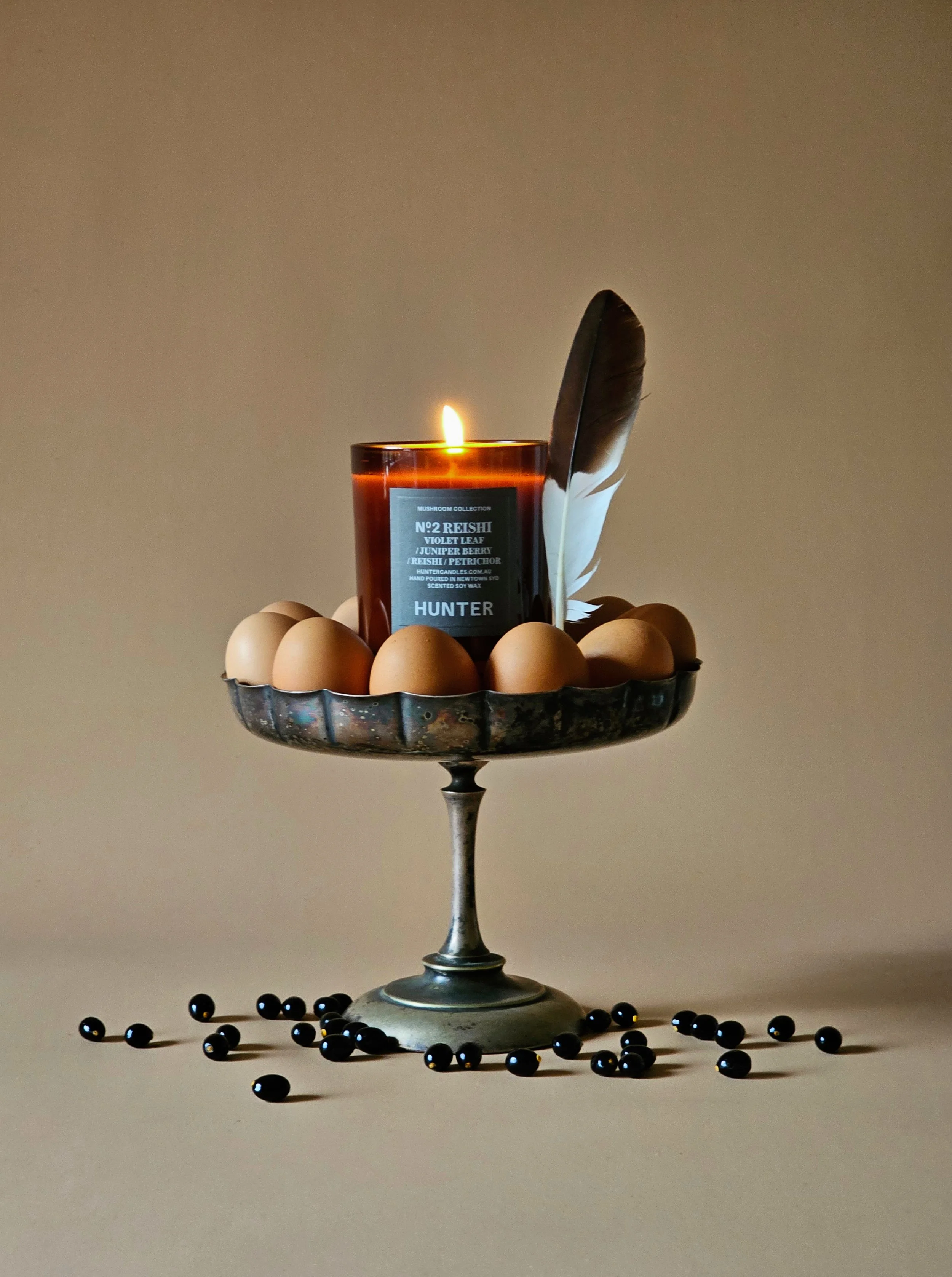 Candle still life with eggs and feather