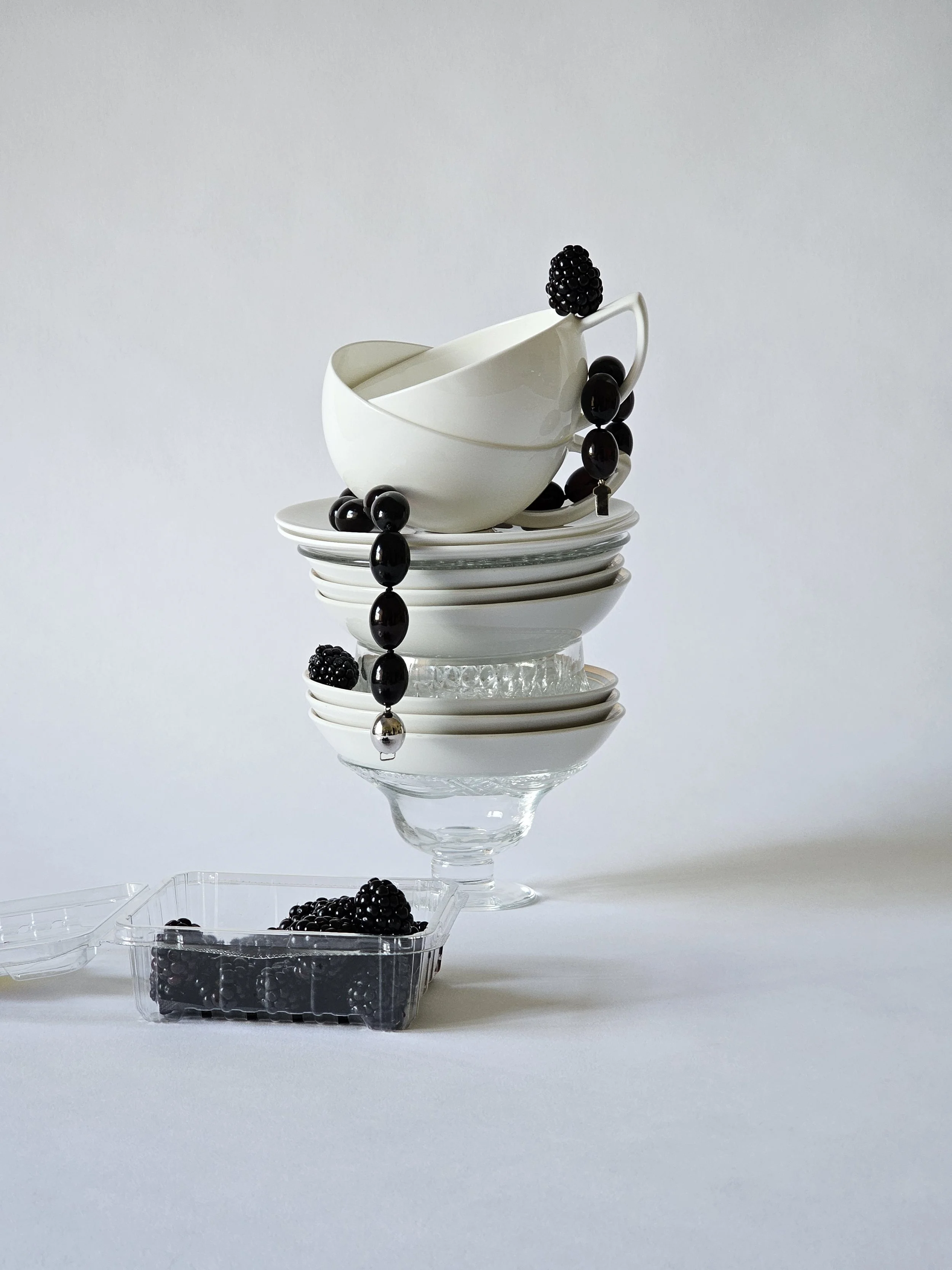 stack of crockery with black beads and blackberries