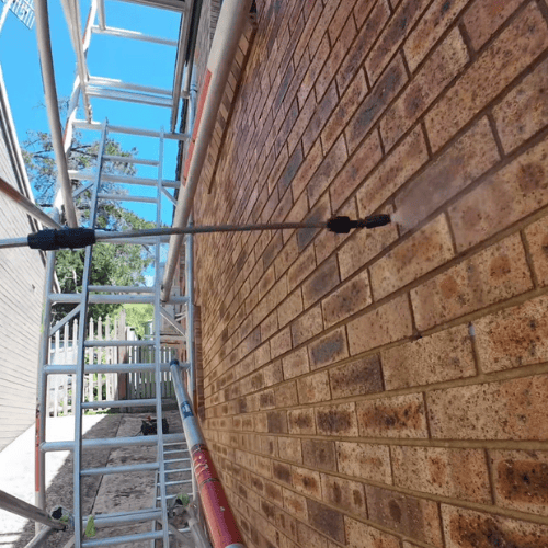 Applying protective sealant to an external brick wall in Cardiff, Newcastle to prevent weather damage and maintain the surface.
