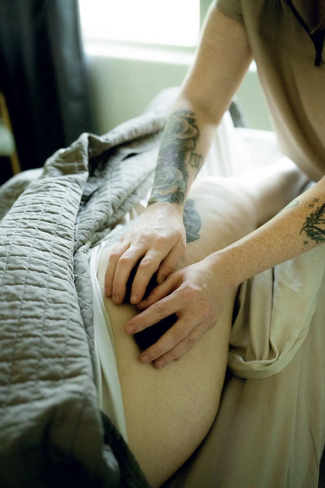 A client receiving a hot stone massage as part of a couples massage experience